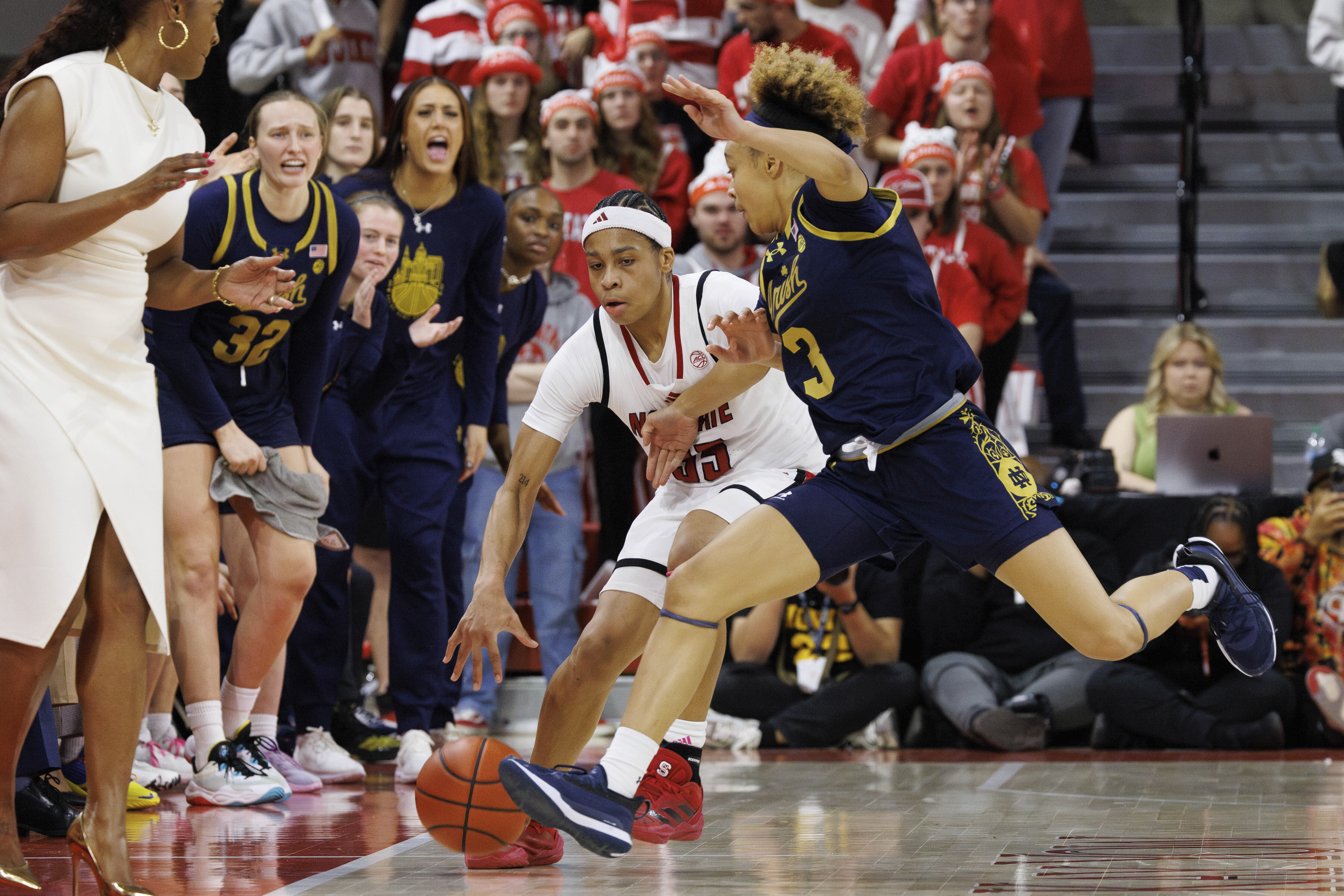 North Carolina State's Zoe Brooks, center left, handles the ball as Notre Dame's Hannah Hidalgo (3) defends during the second half of an NCAA college basketball game in Raleigh, N.C., Sunday, Feb. 23, 2025. 