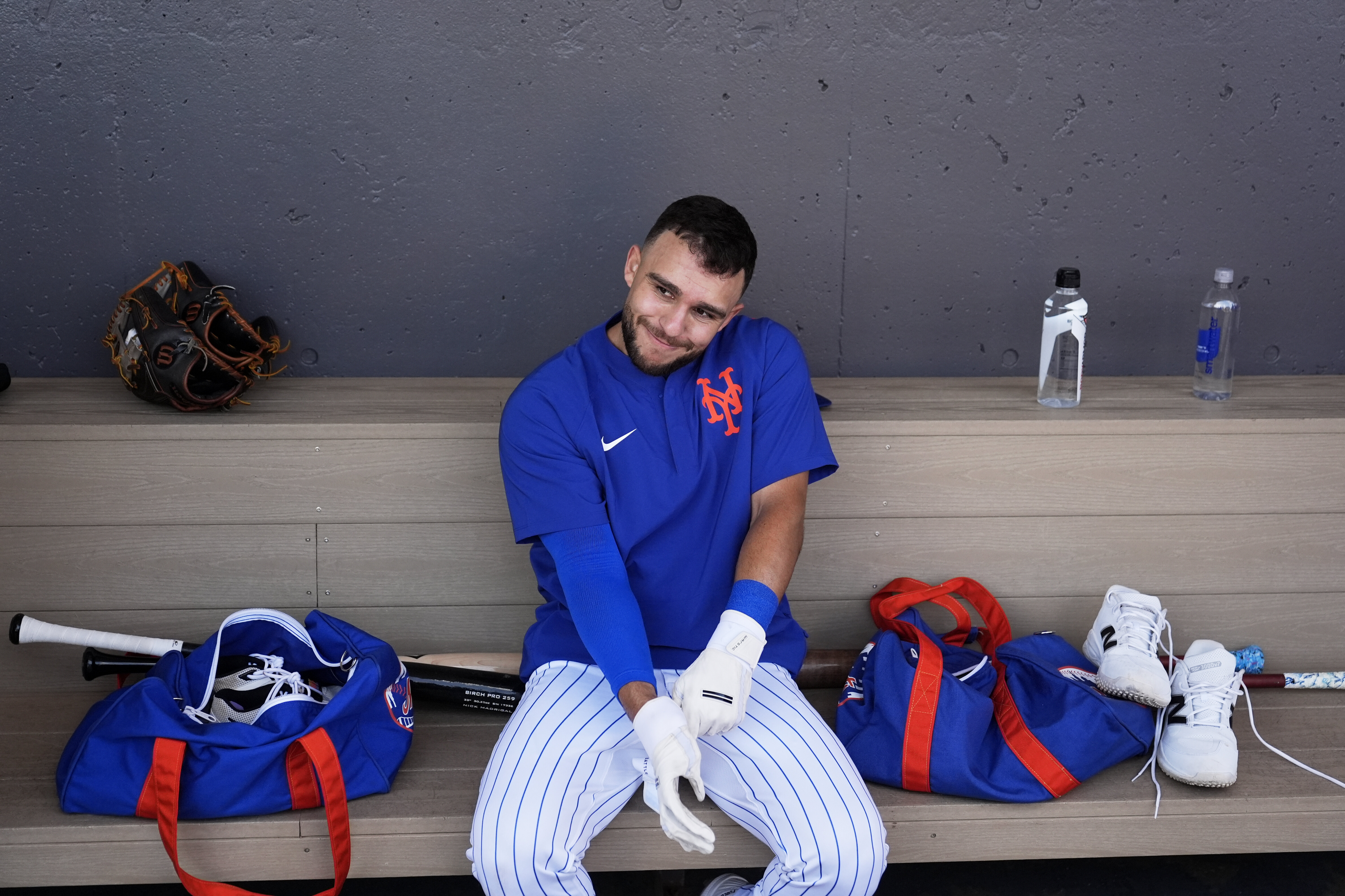 New York Mets' Nick Madrigal puts on batting gloves during a spring training baseball practice Monday, Feb. 17, 2025, in Port St. Lucie, Fla. 