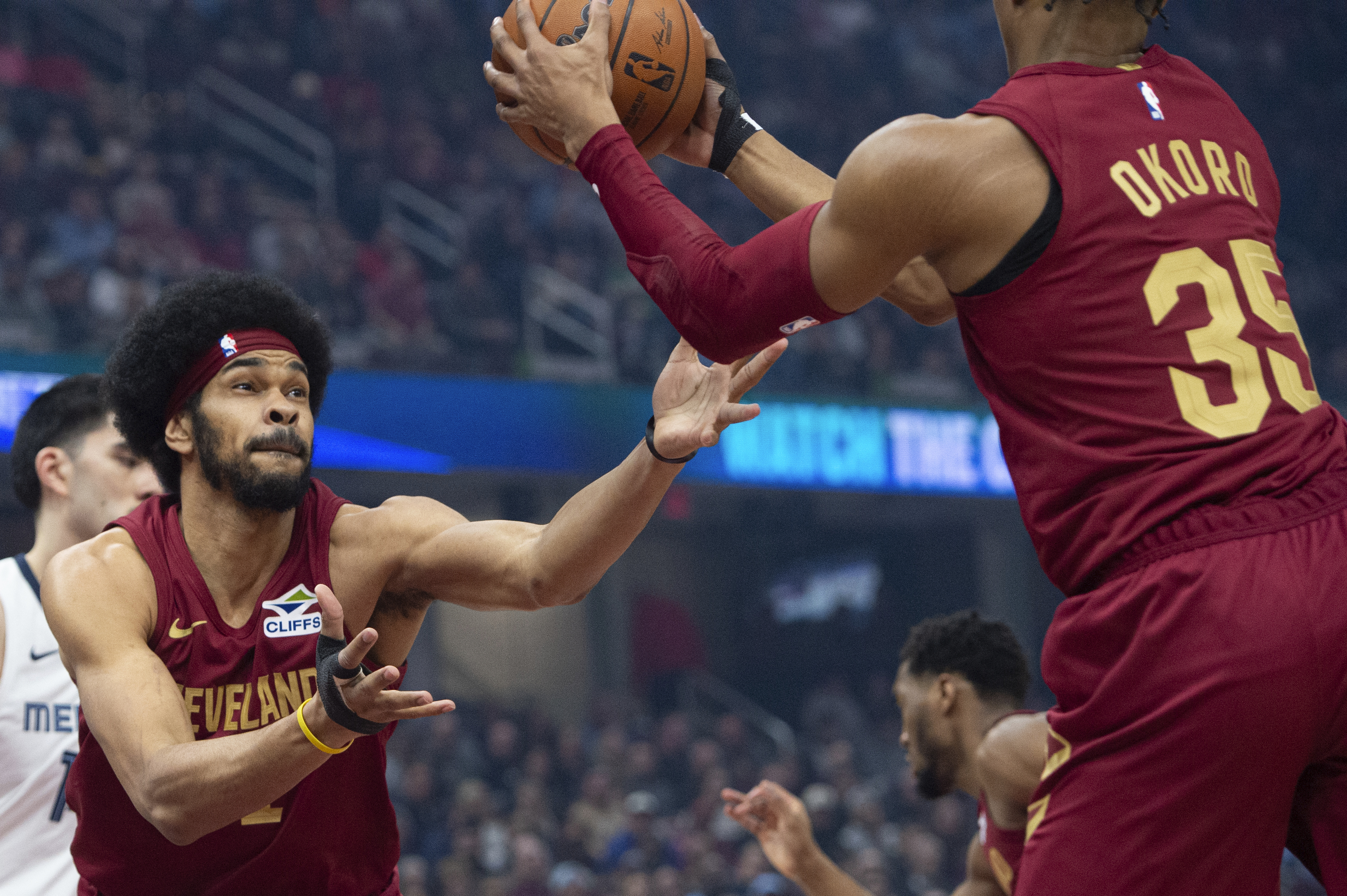 Cleveland Cavaliers' Isaac Okoro (35) grabs a rebound as teammate Jarrett Allen, front left, assists during the first half of an NBA basketball game against the Memphis Grizzlies in Cleveland, Sunday, Feb. 23, 2025. 