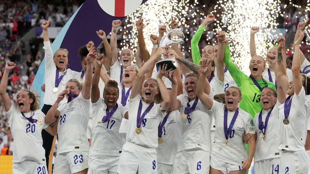 FILE - England's Leah Williamson, center left, and Millie Bright lift the trophy after winning the Women's Euro 2022 final soccer match between England and Germany at Wembley stadium in London, July 31, 2022. England won 2-1.