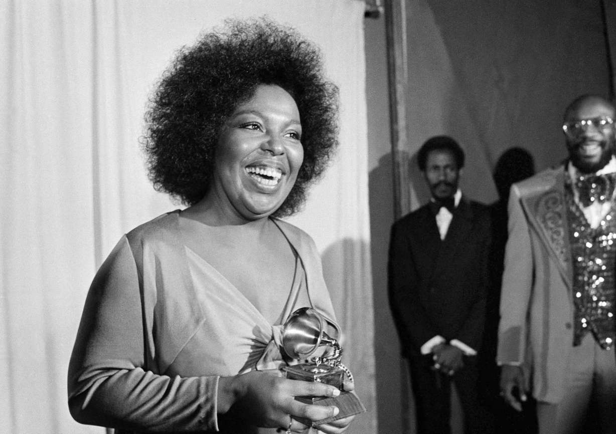 Roberta Flack holds the Grammy award for her record, "Killing Me Softly With His Song" as singer Isaac Hayes, right, looks on at the Grammy Awards in Los Angeles on March 4, 1974.