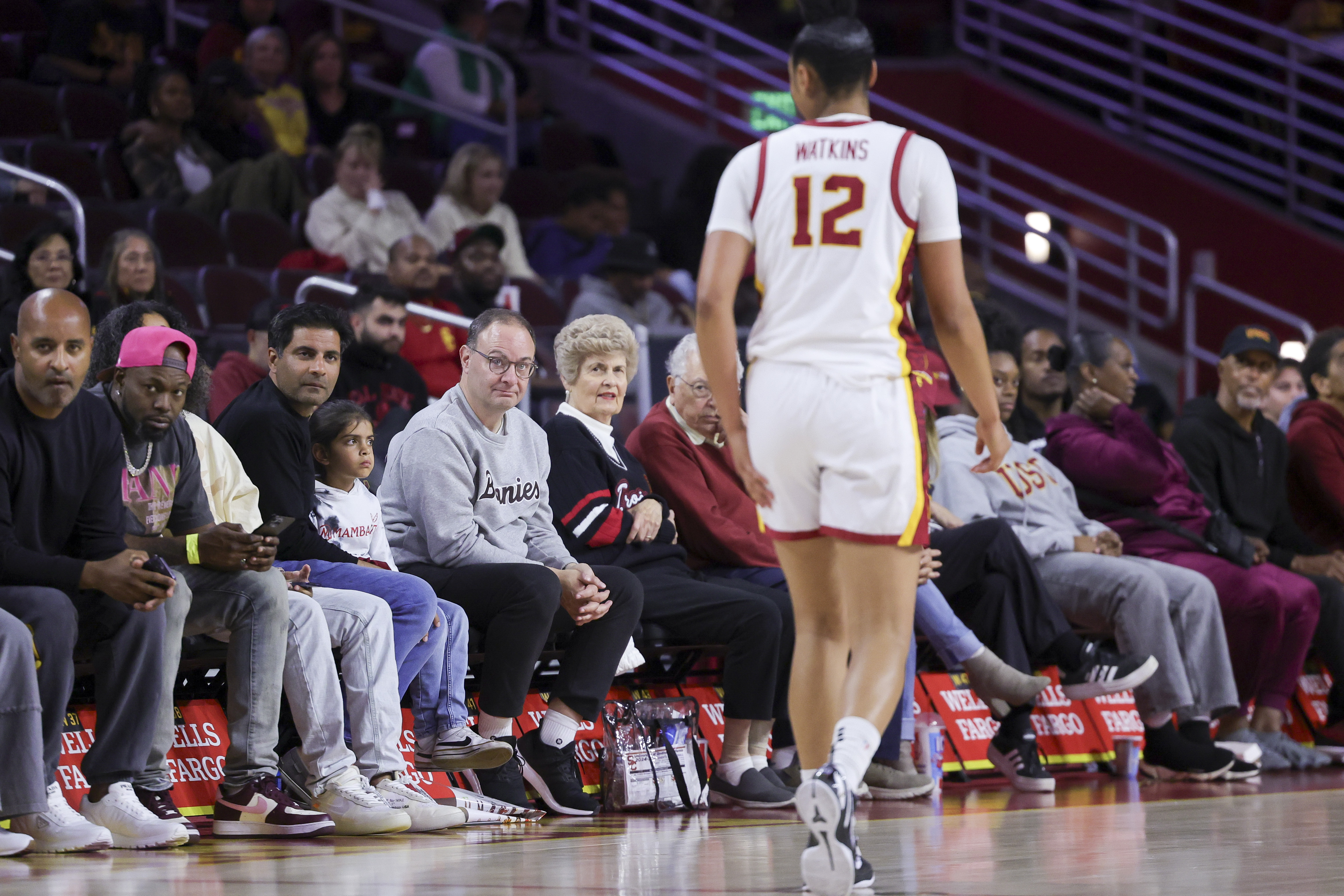 FILE - Former NBA reporter and current St. Bonaventure men's basketball general manager Adrian Wojnarowski, center left, watches as Southern California guard JuJu Watkins walks past during the second half of an NCAA women's basketball game, Nov. 12, 2024, in Los Angeles. 