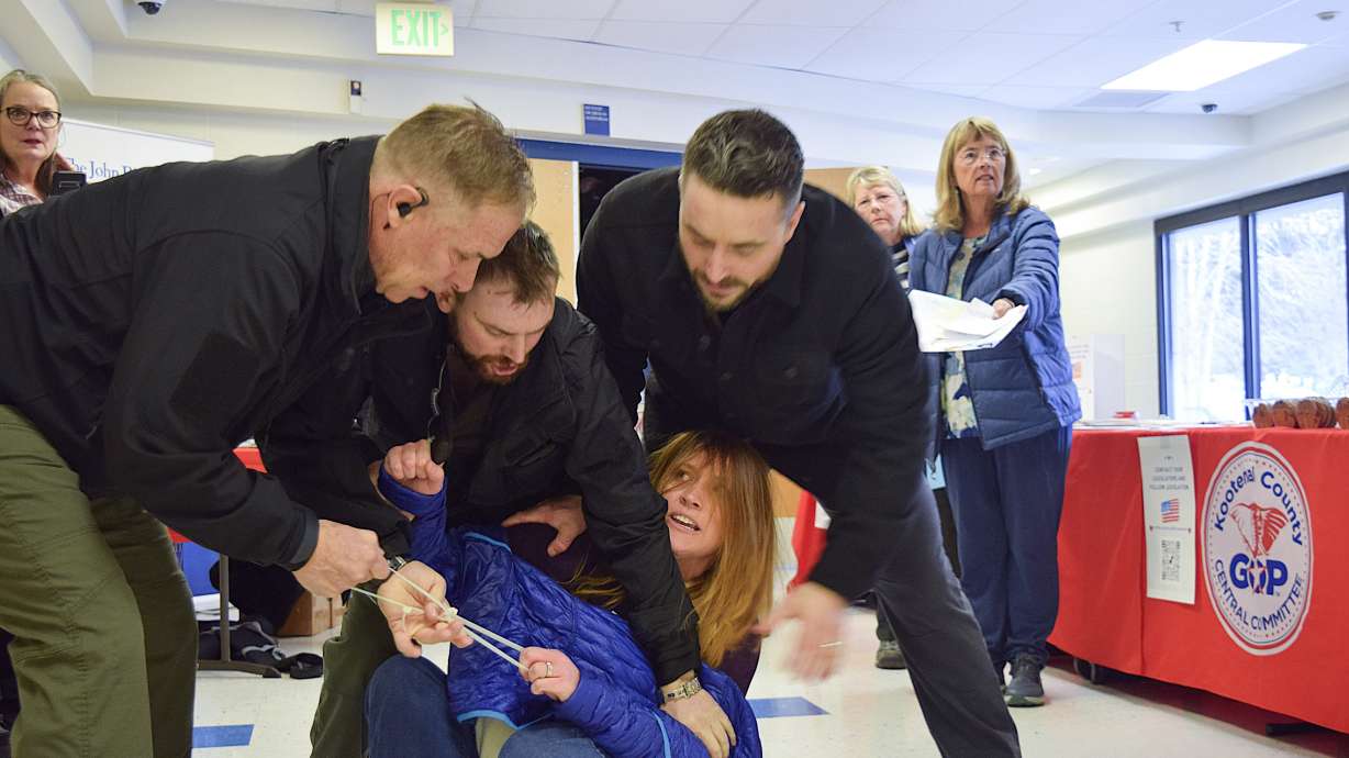 Employees of a security firm, LEAR Asset Management, drag Post Falls resident Teresa Borrenpohl out of a town hall meeting on Saturday in Post Falls, Idaho.
