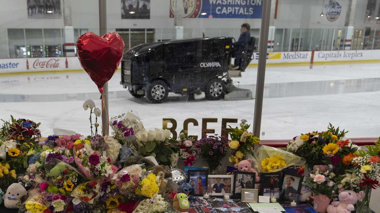 An ice resurfacer prepares the ice as a memorial is seen along the boards at MedStar Capitals Iceplex Sunday, Feb. 2, 2025, in Arlington, Va., for the figure skaters who were among the 67 victims of a mid-air collision between an Army helicopter and an American Airlines flight from Kansas.