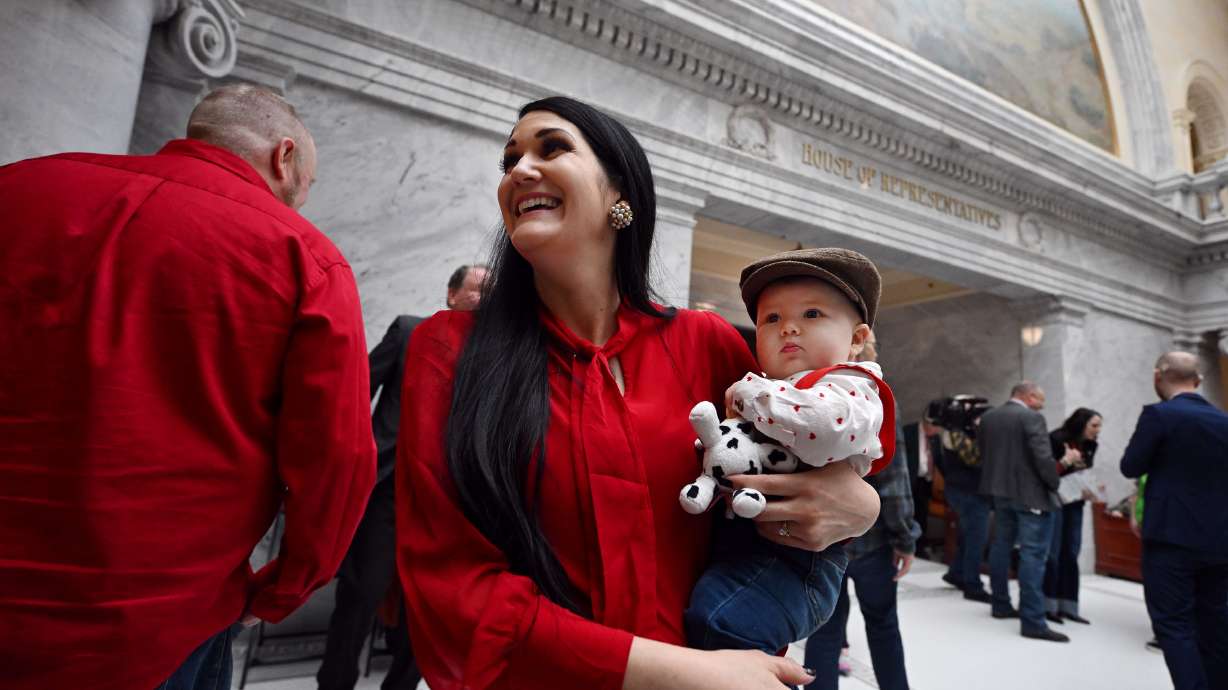 Rep. Ashlee Matthews, D-West Jordan, goes about her responsibilities outside the House of Representatives while carrying her new baby Joey Matthews on Feb. 14. Joey gets passed around from staff to representative, whoever would like to hold him during floor time.