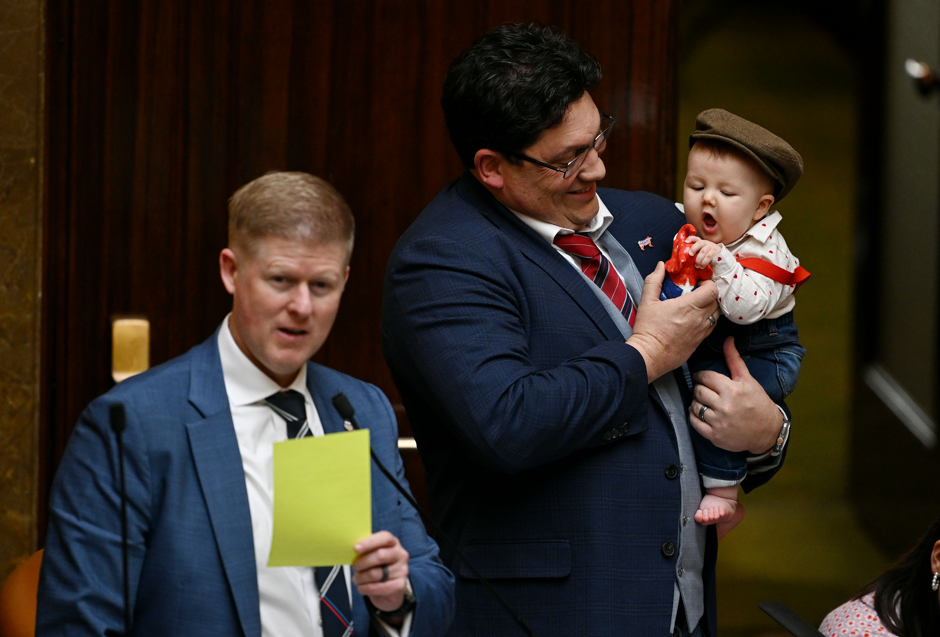 Rep. Ryan D. Wilcox, R-Ogden, holds Joey Matthews in the House of Representatives as Rep. Jon Hawkins, R-Pleasant Grove, speaks on Feb. 14. Joey gets passed around from staff to representative whoever would like to hold him during floor time.