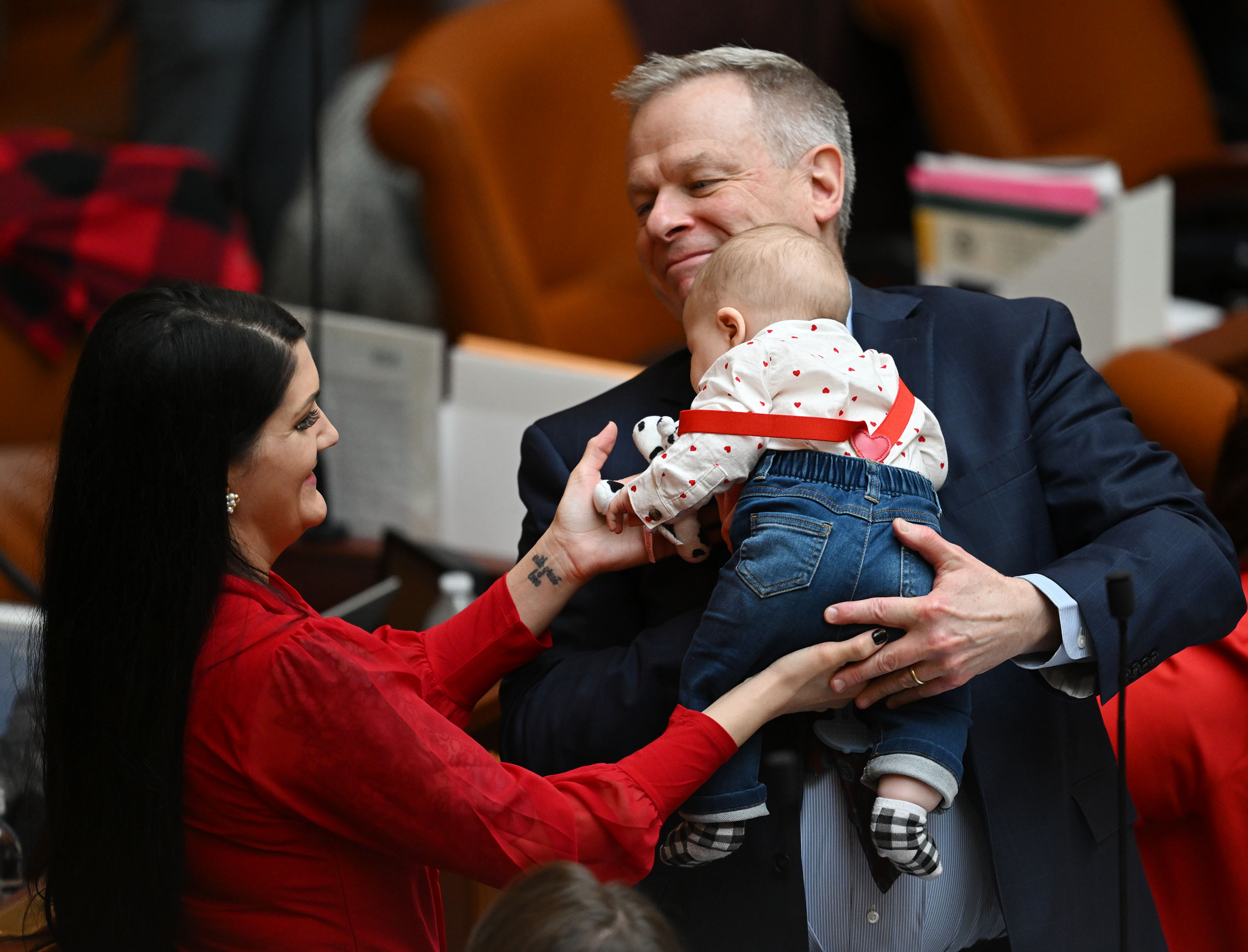 Rep. Ashlee Matthews, D-West Jordan, hands her son Joey to Rep. Doug Owens, D-Millcreek, as she goes about her responsibilities in the House of Representatives on Feb. 14. Joey gets passed around from staff to representative, whoever would like to hold him during floor time.