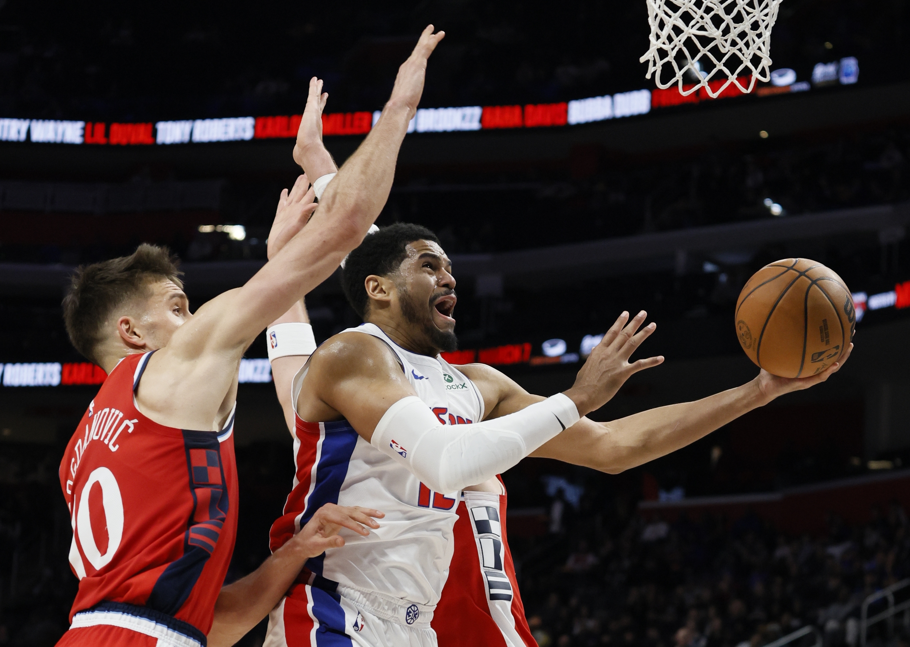 Detroit Pistons forward Tobias Harris, right, goes to the basket between Los Angeles Clippers guard Bogdan Bogdanovic (10) and center Ivica Zubac, right, during the first half of an NBA basketball game Monday, Feb. 24, 2025, in Detroit. 