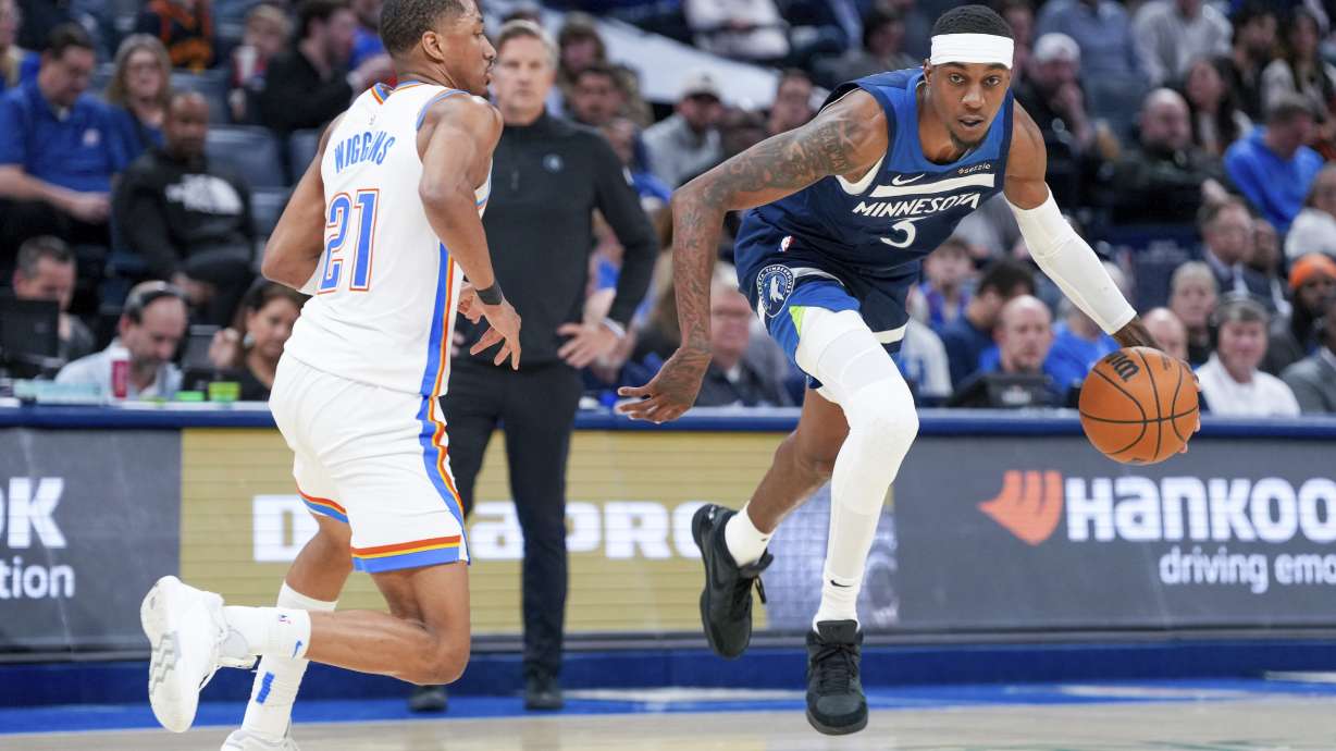 Minnesota Timberwolves forward Jaden McDaniels, right, pushes past Oklahoma City Thunder guard Aaron Wiggins, left, during the second half of an NBA basketball game, Monday, Feb. 24, 2025, in Oklahoma City.