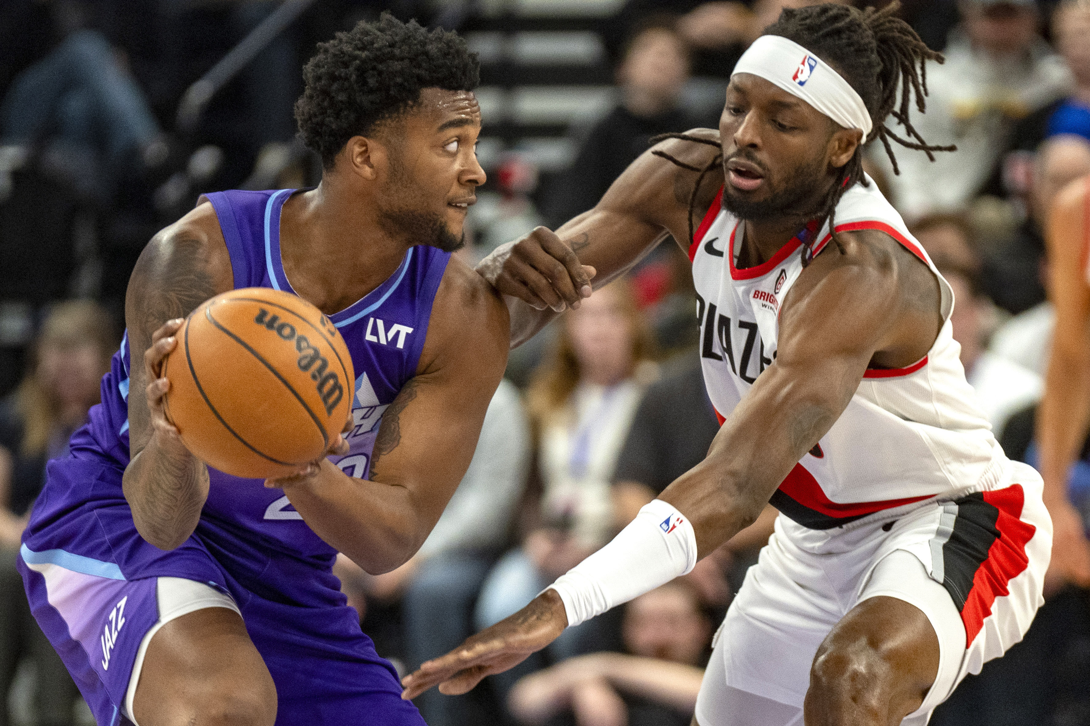 Utah Jazz forward Brice Sensabaugh, left, looks downcourt as Portland Trail Blazers forward Jerami Grant, right, defends during the first half of an NBA basketball game Monday, Feb. 24, 2025, in Salt Lake City. 
