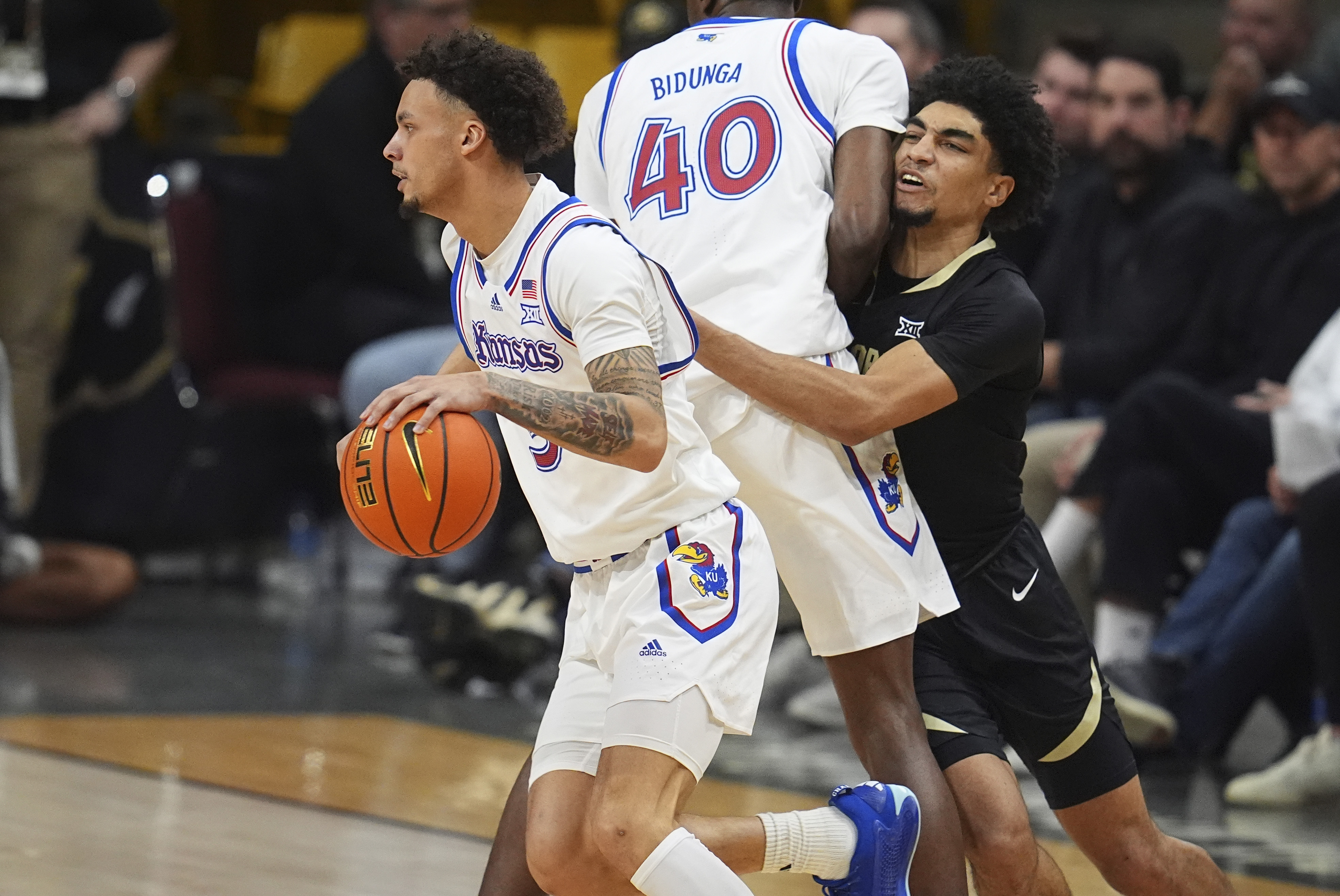 Kansas guard Zeke Mayo, left, drives past forward Flory Bidunga (40) as he blocks Colorado guard RJ Smith in the second half of an NCAA college basketball game Monday, Feb. 24, 2025, in Boulder, Colo.