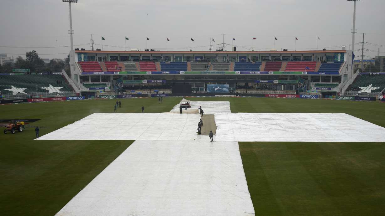 Groundsmen cover the pitch and field area due to low rain fall before start of the ICC Champions Trophy cricket match between Australia and South Africa, in Rawalpindi, Pakistan Tuesday, Feb. 25, 2025.