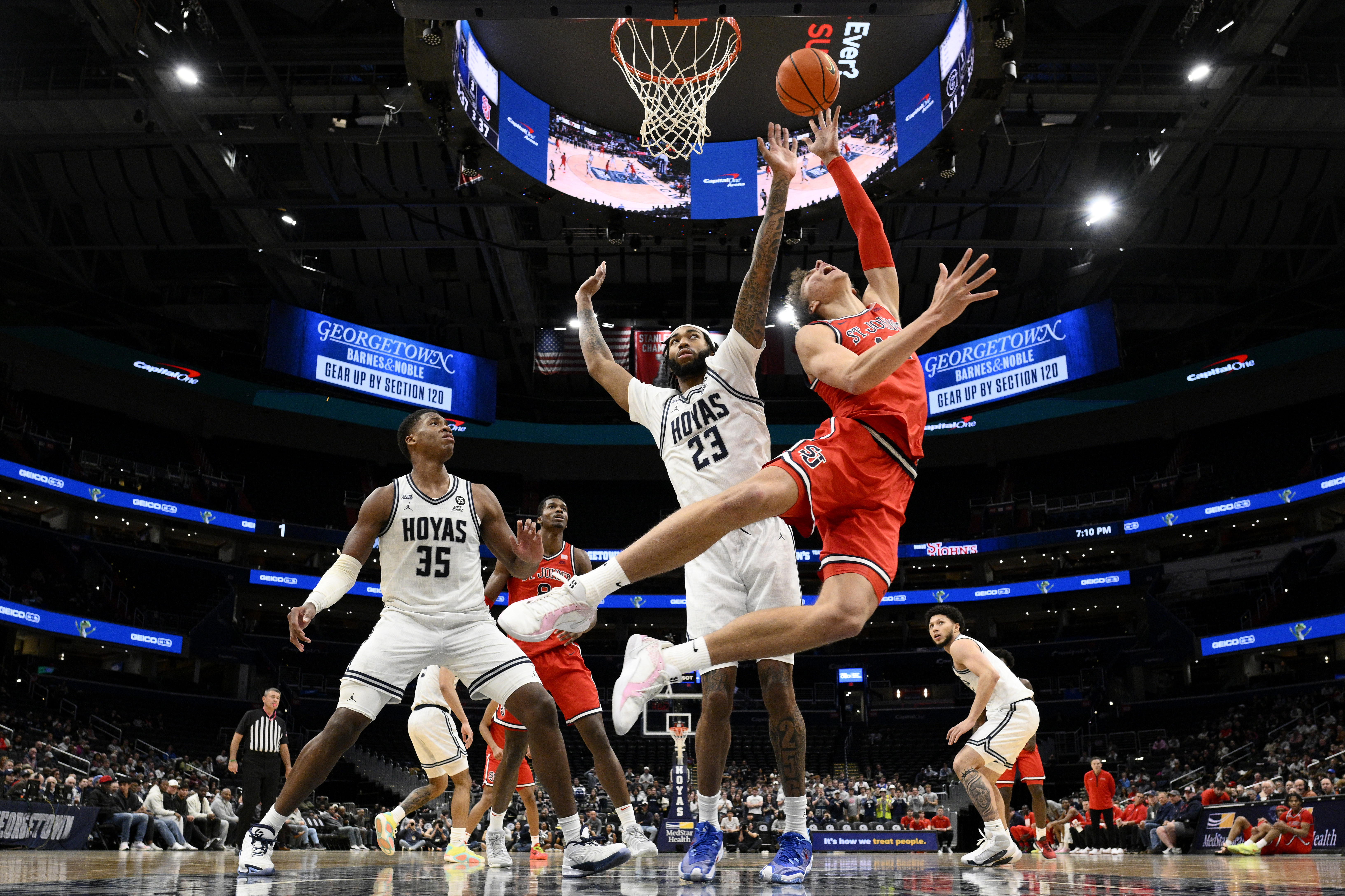 St. John's forward Ruben Prey, right, goes to the basket against Georgetown forwards Jordan Burks (23) and Thomas Sorber (35) during the first half of an NCAA college basketball game, Tuesday, Jan. 28, 2025, in Washington. 