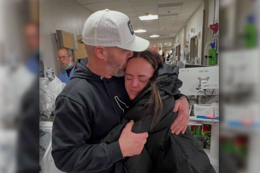 Jaquoy Holman, right, hugs her dad after almost three weeks in Switzerland caring for her husband Justin Holman, who was paralyzed in a ski accident, in an undated photo.