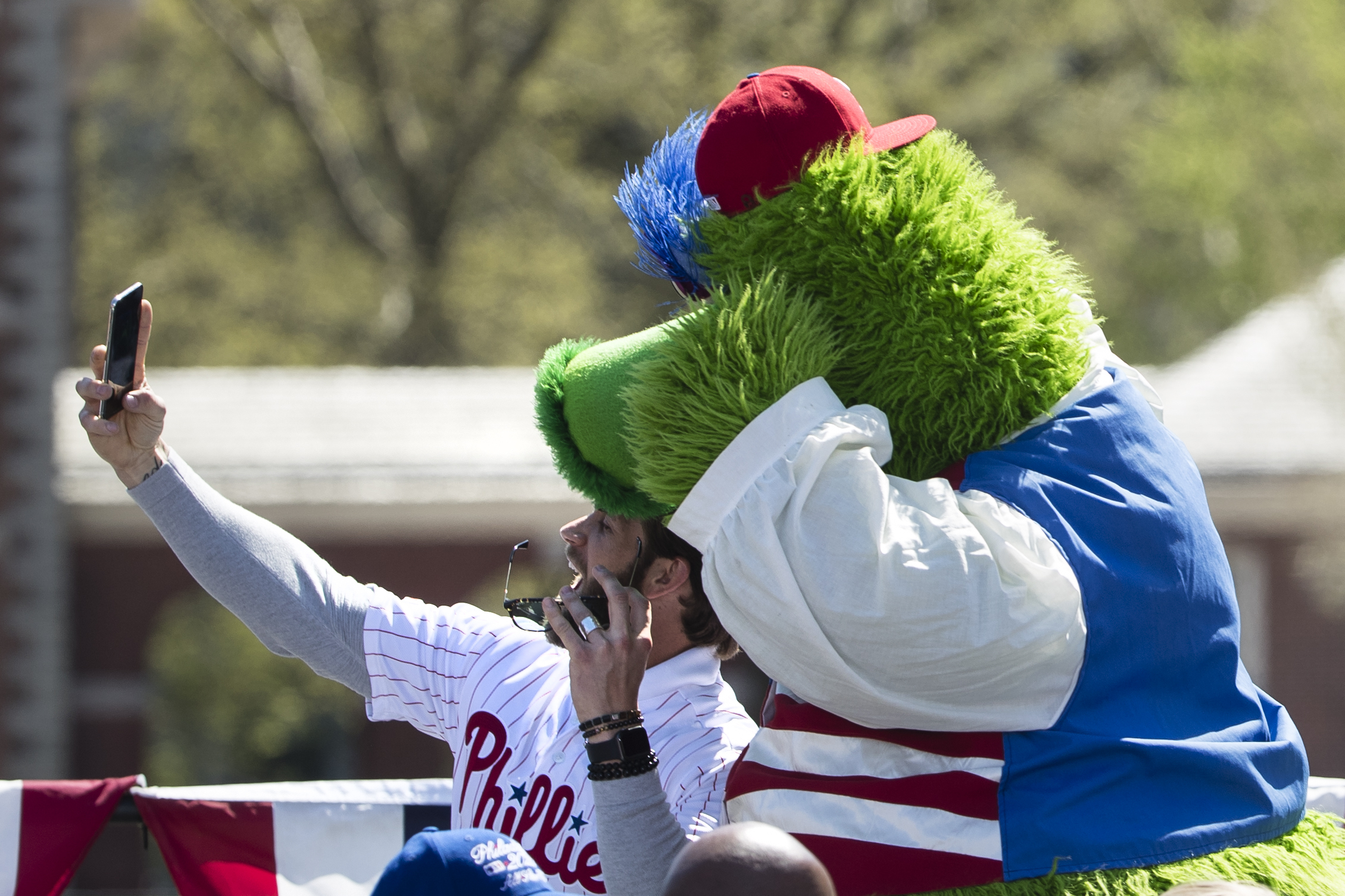 FILE - Philadelphia Phillies' Bryce Harper makes a selfie with the team mascot, the Phillie Phanatic, during a Major League Baseball news conference, April 16, 2019, on Independence Mall in Philadelphia. 