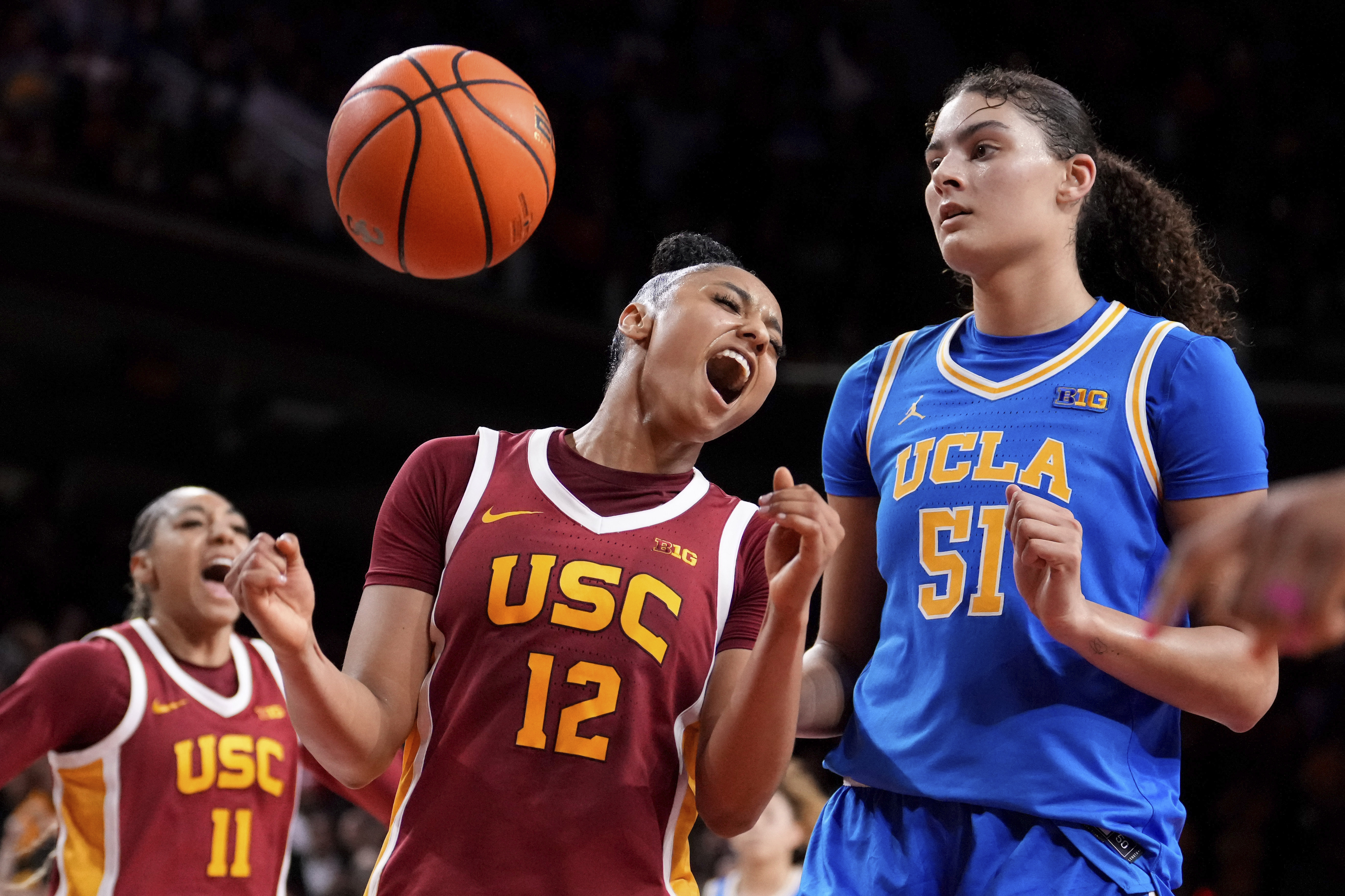 Southern California guard JuJu Watkins, center, celebrates along with guard Kennedy Smith, left, after scoring as UCLA center Lauren Betts looks on during the second half of an NCAA college basketball game, Thursday, Feb. 13, 2025, in Los Angeles.