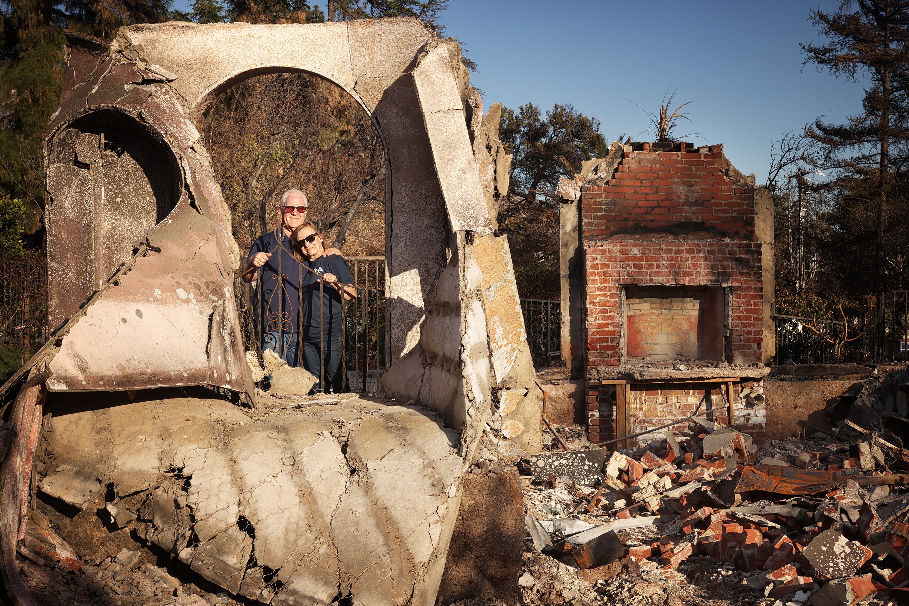 Mike and Susan Christensen stand amid the ruins