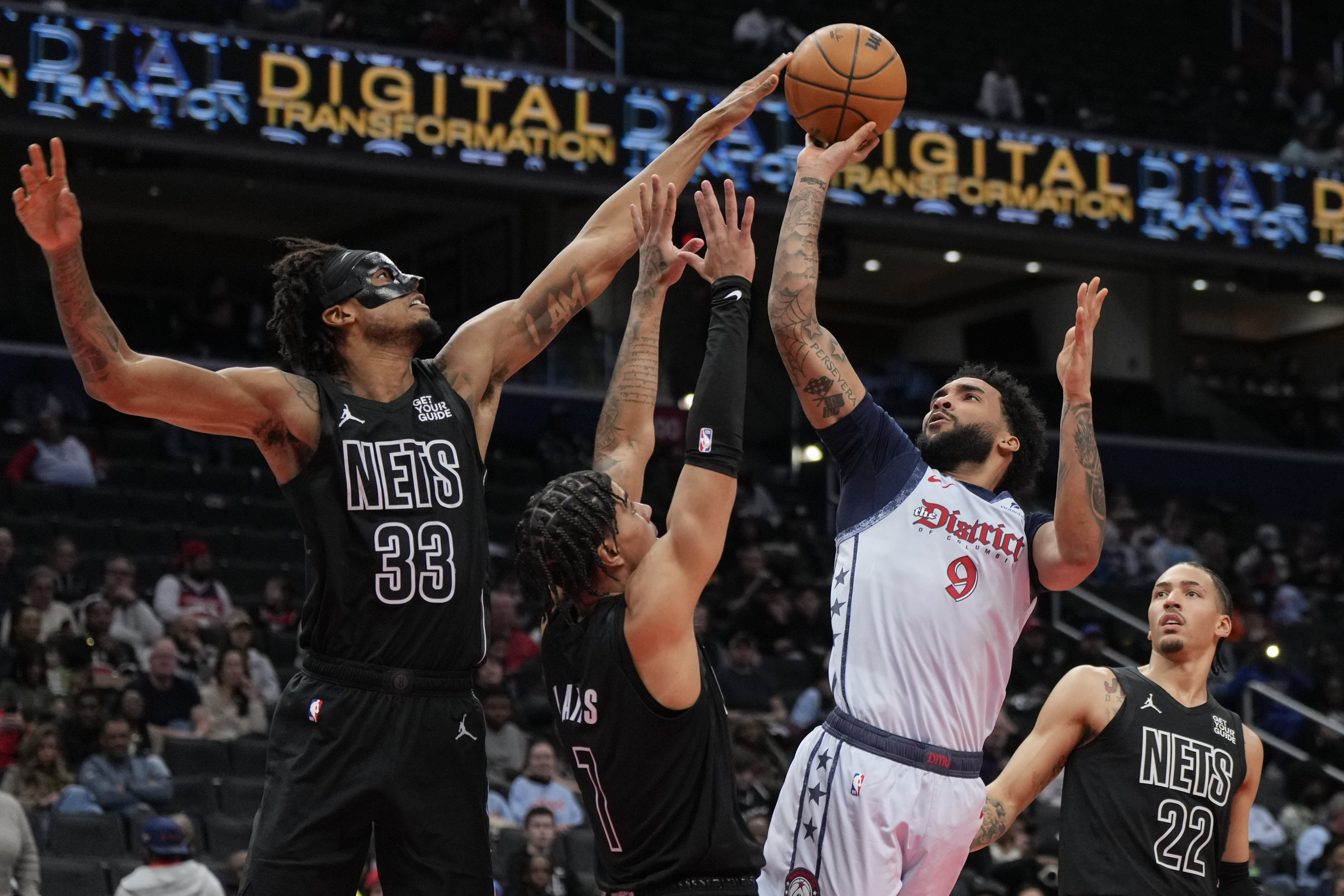 Washington Wizards forward Justin Champagne (9) goes up to shoot against Brooklyn Nets center Nic Claxton (33), guard Killian Hayes (7), and forward Jalen Wilson (22) during the first half of an NBA basketball game Monday, Feb. 24, 2025, in Washington. 