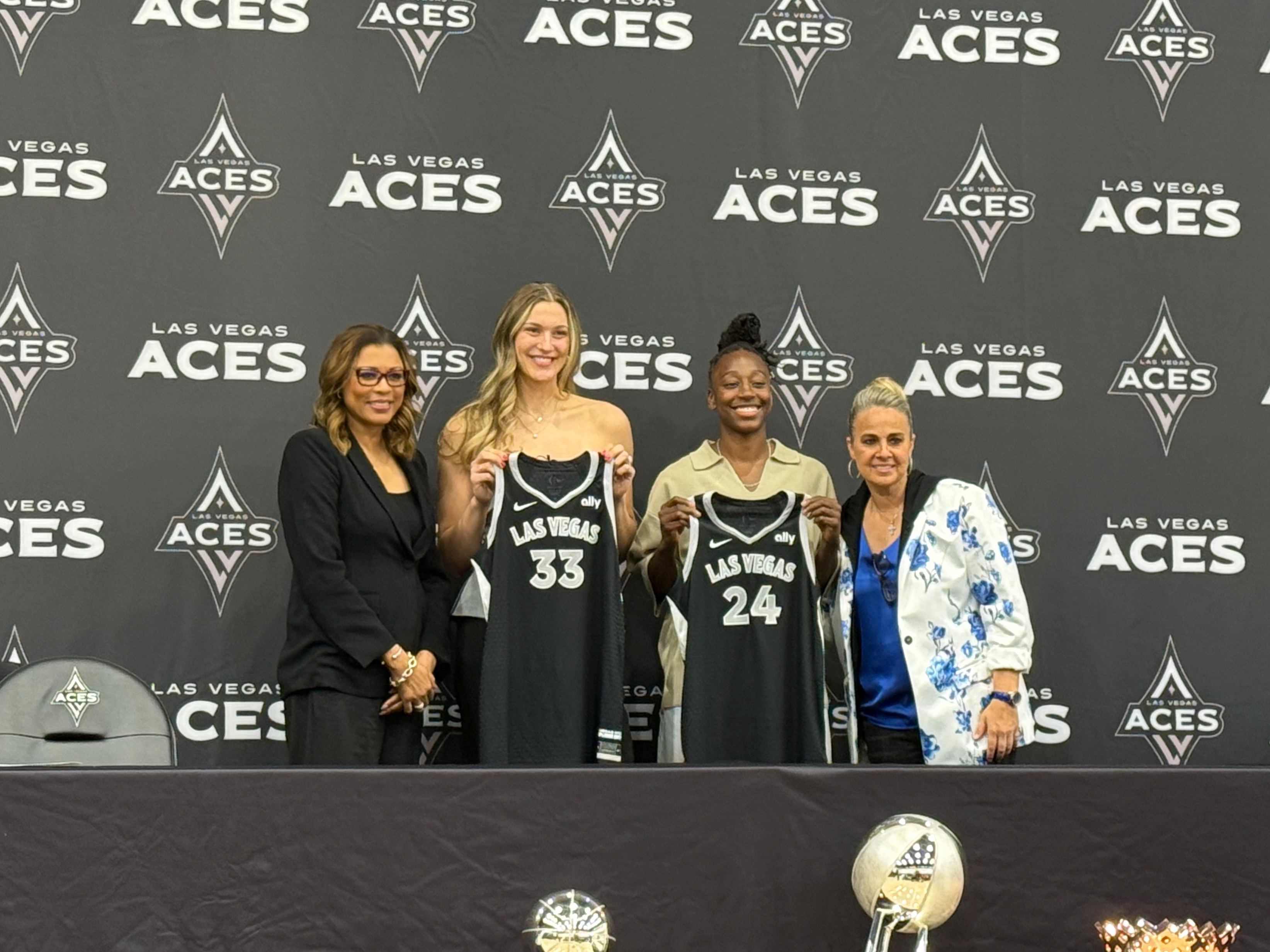 Las Vegas Aces' Liz Kitley, center left, and Jewell Loyd, center right, pose for a photo alongside President Nikki Fargas, left, and Becky Hammon at a presser in Las Vegas, Tuesday, Feb. 25, 2025. 