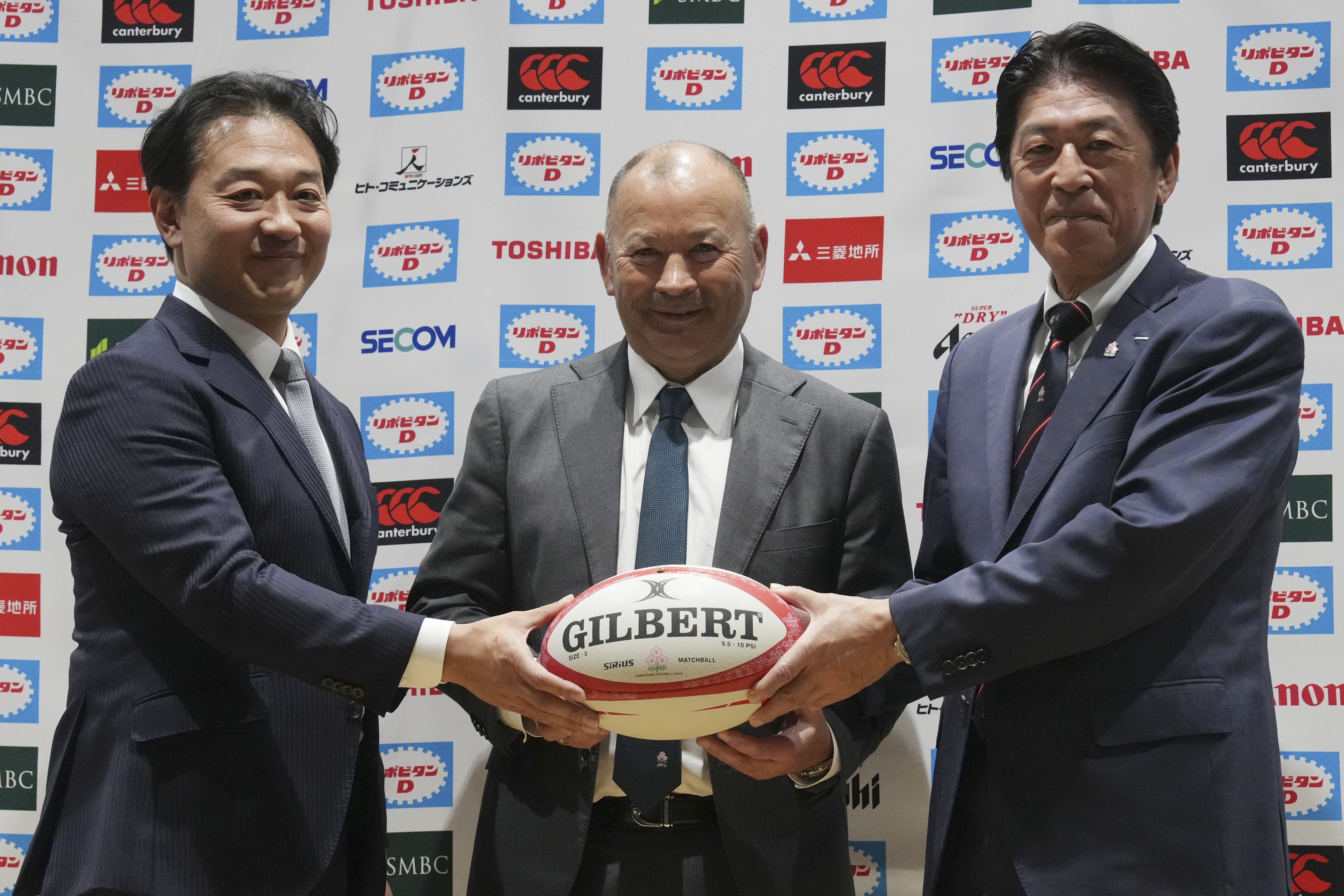 FILE - Eddie Jones of Australia, center, poses for photographers with Japan Rugby Football Union (JRFU) Chairman Kensuke Iwabuchi, left, and JRFU President Masato Tsuchida, right, during a news conference Thursday, Dec. 14, 2023, in Tokyo. 