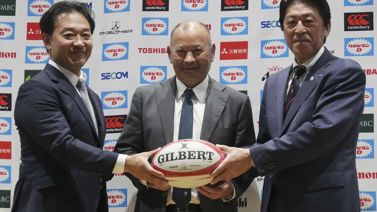 FILE - Eddie Jones of Australia, center, poses for photographers with Japan Rugby Football Union (JRFU) Chairman Kensuke Iwabuchi, left, and JRFU President Masato Tsuchida, right, during a news conference Thursday, Dec. 14, 2023, in Tokyo.