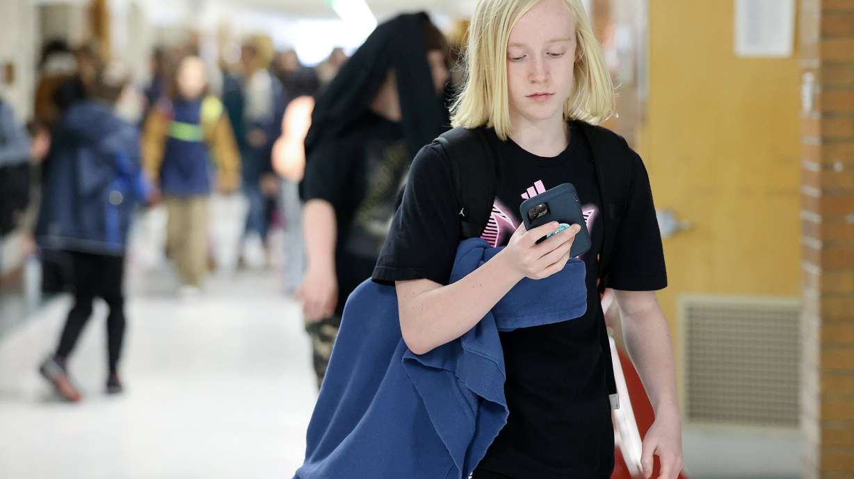 Cruise Palmer uses his cellphone after school at Evergreen Junior High School in Millcreek on Jan. 10, 2024. Phones are banned at Evergreen during the school day but are allowed after the final bell rings.