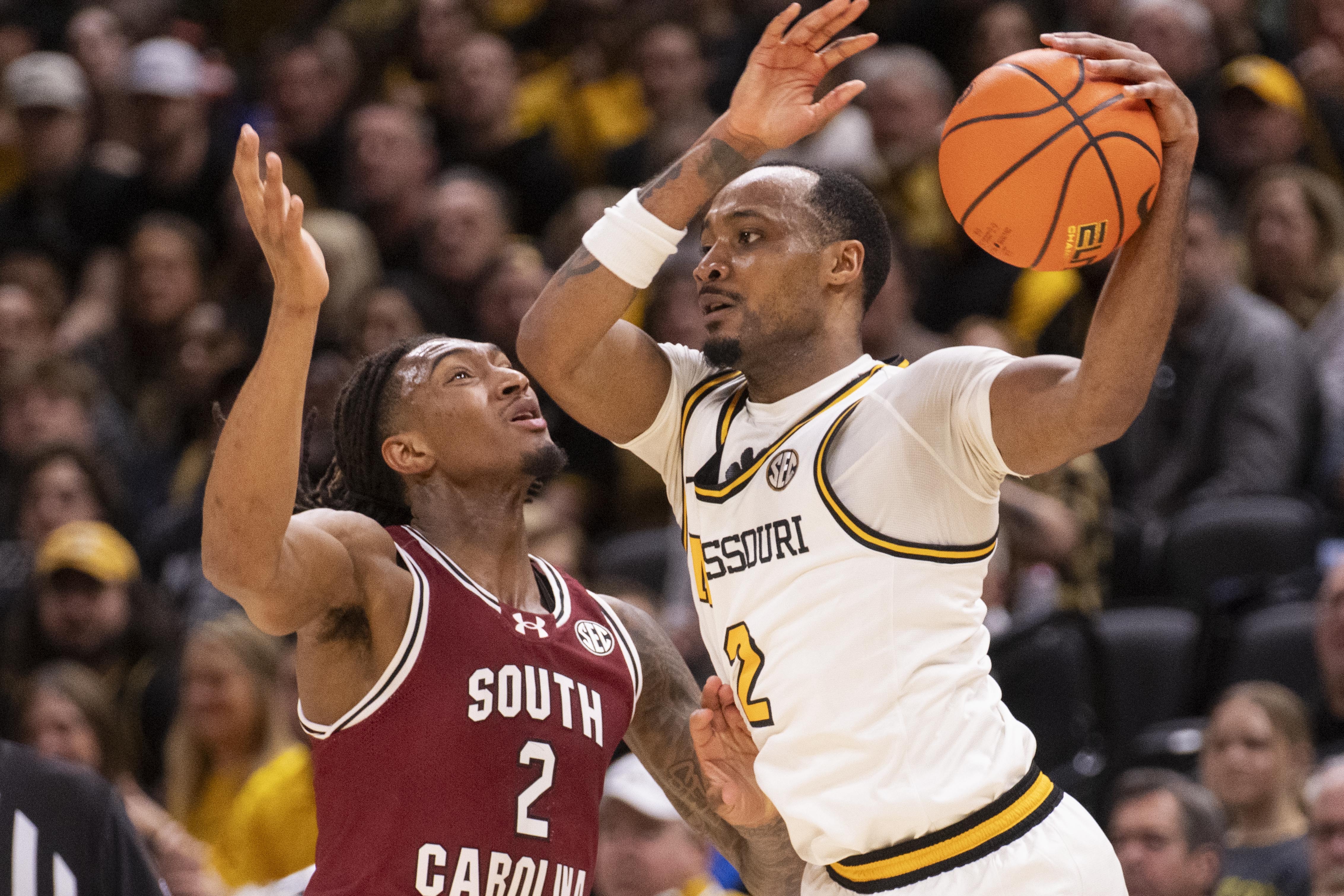 Missouri's Tamar Bates, right, passes the ball around South Carolina's Zachary Davis, left, during the first half of an NCAA college basketball game Tuesday, Feb. 25, 2025, in Columbia, Mo. 