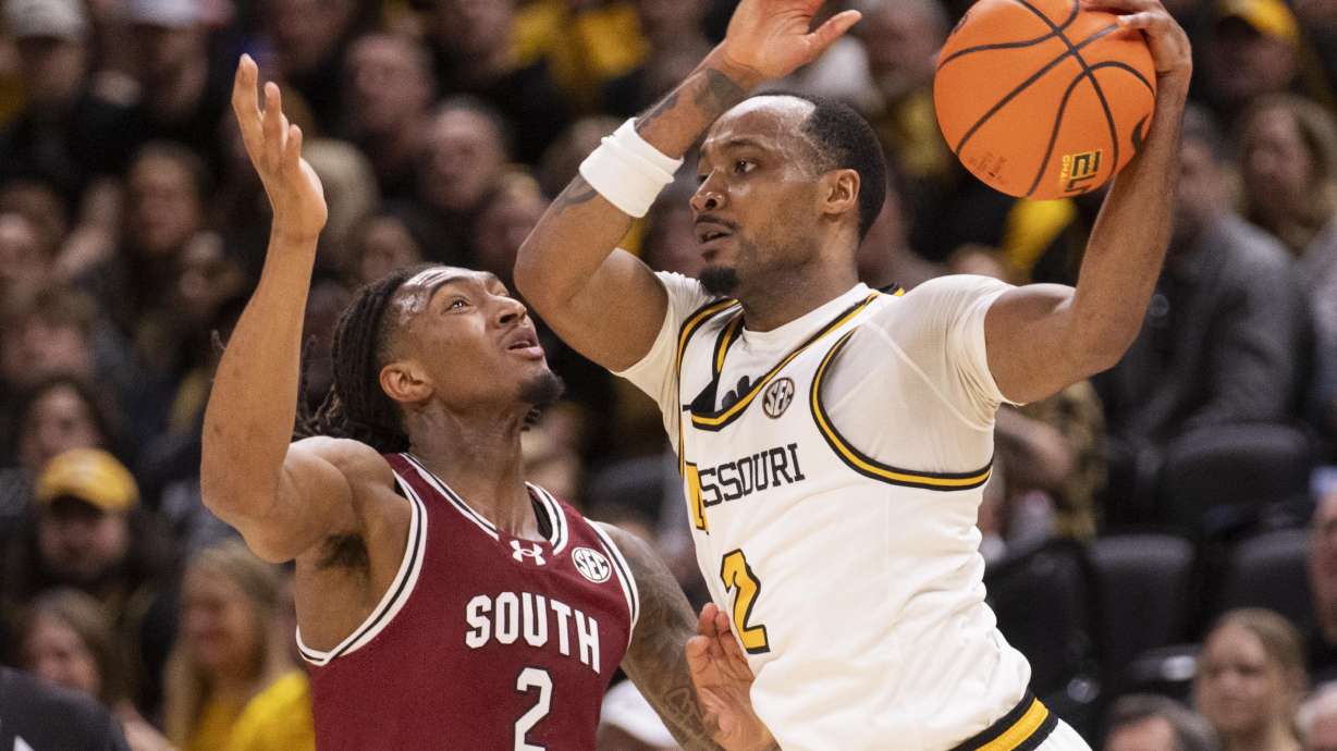Missouri's Tamar Bates, right, passes the ball around South Carolina's Zachary Davis, left, during the first half of an NCAA college basketball game Tuesday, Feb. 25, 2025, in Columbia, Mo.