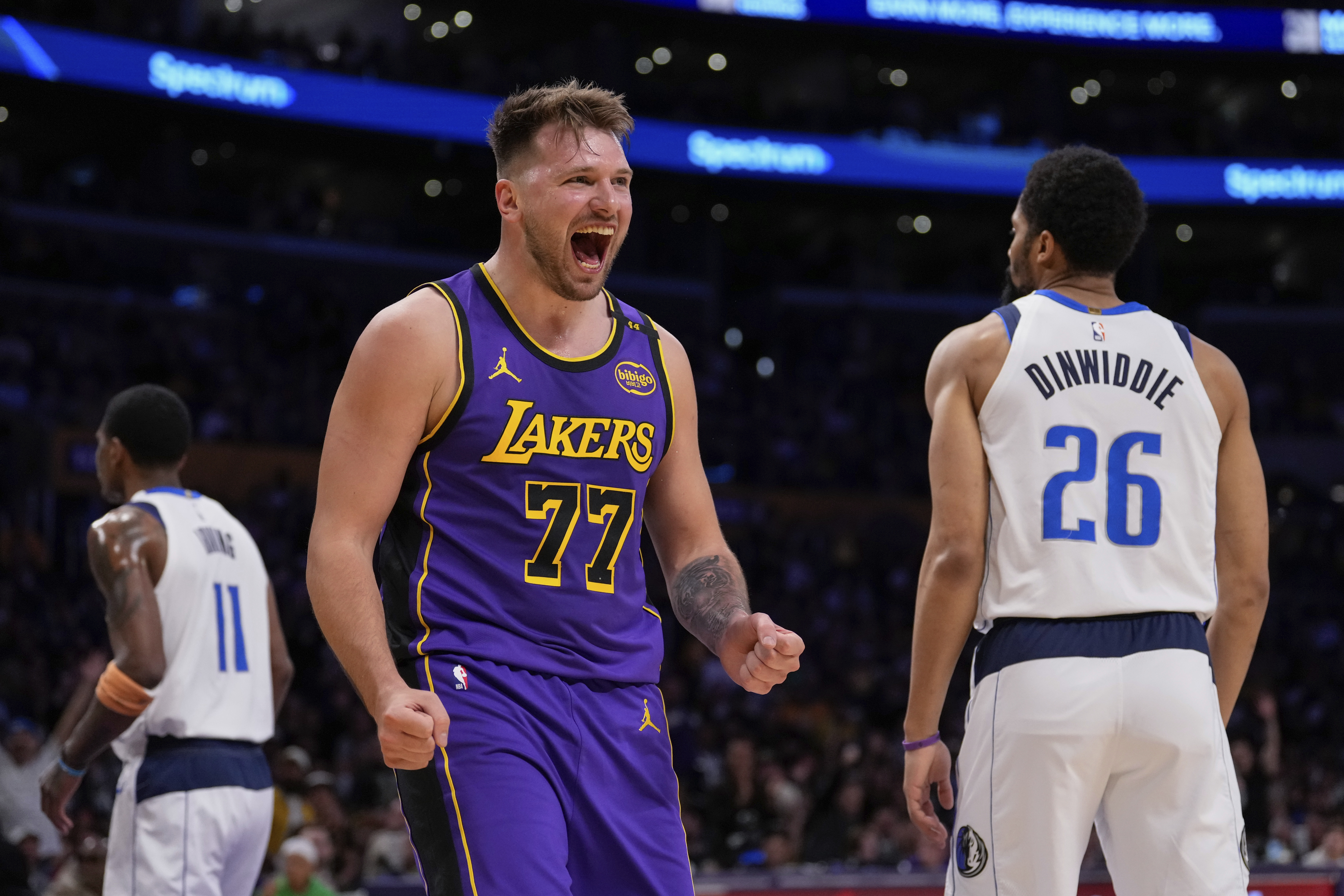 Los Angeles Lakers guard Luka Doncic (77) reacts next to Dallas Mavericks guard Spencer Dinwiddie (26) after scoring an drawing a foul during the first half of an NBA basketball game Tuesday, Feb. 25, 2025, in Los Angeles. 