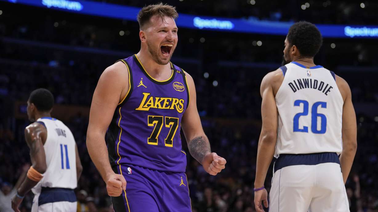 Los Angeles Lakers guard Luka Doncic (77) reacts next to Dallas Mavericks guard Spencer Dinwiddie (26) after scoring an drawing a foul during the first half of an NBA basketball game Tuesday, Feb. 25, 2025, in Los Angeles.