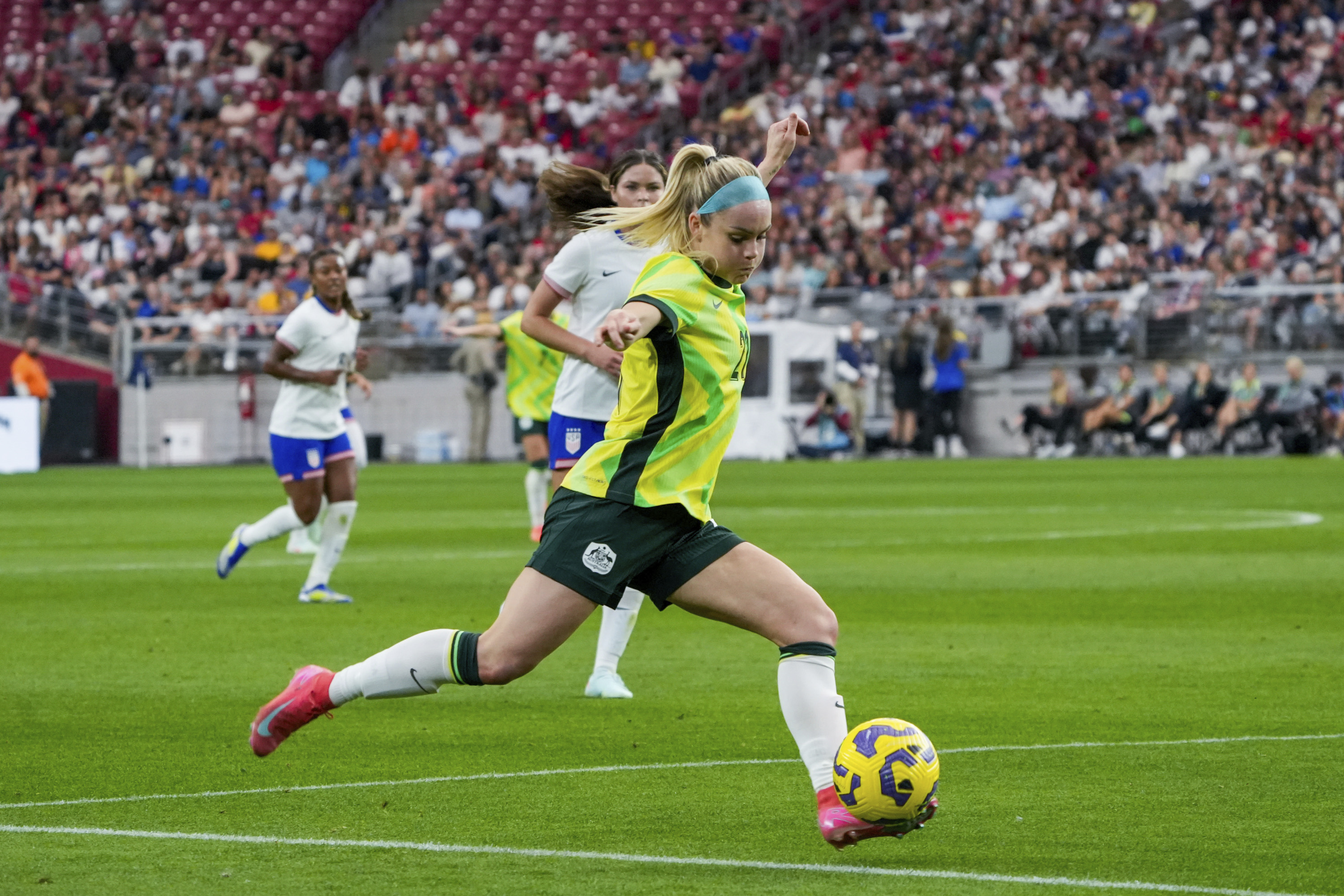 Australia defender Ellie Carpenter, foreground, dribbles during the first half of a group stage match against the United States in the SheBelieves Cup women's soccer tournament, Sunday, Feb. 23, 2025, in Glendale, Ariz. 