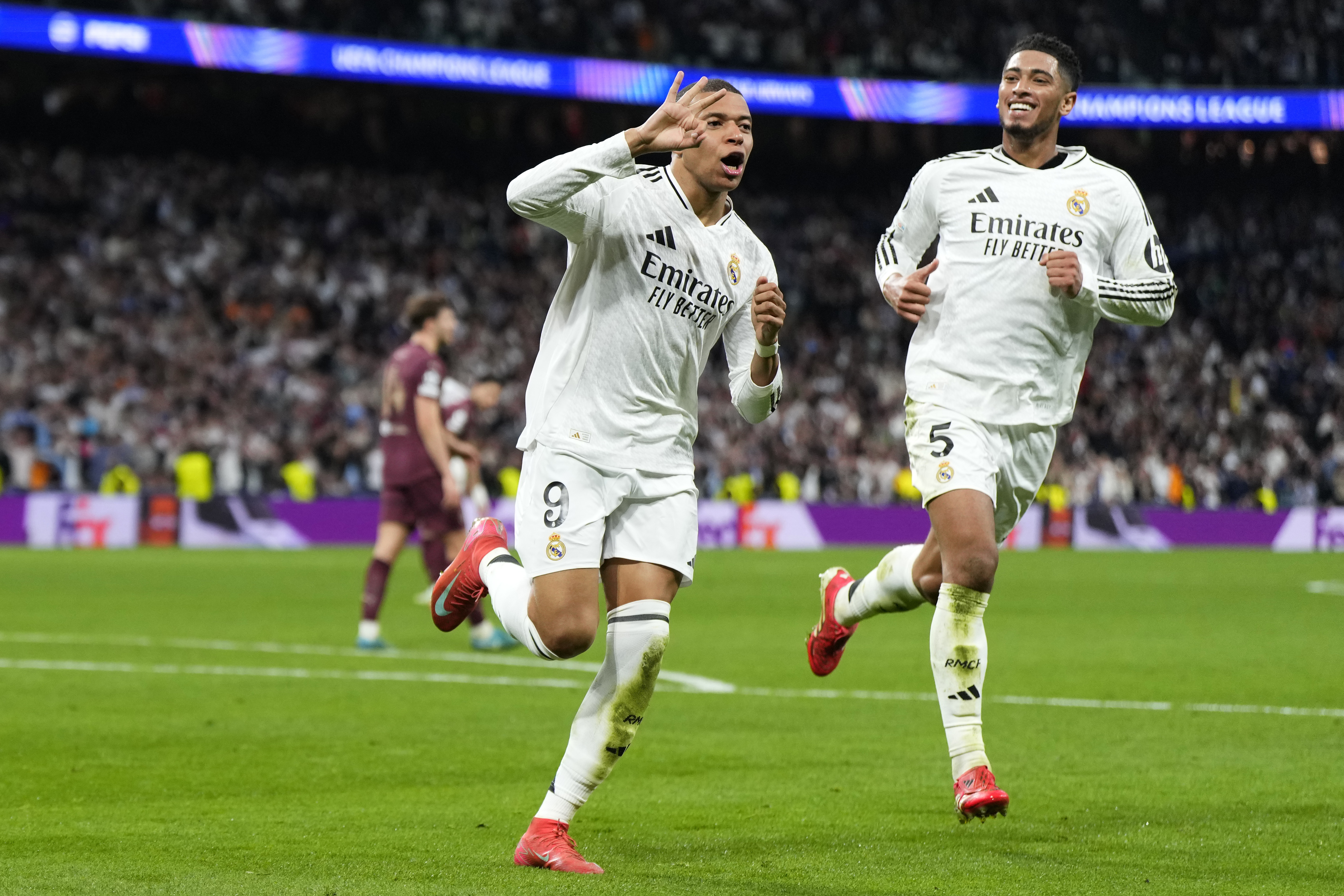 Real Madrid's Kylian Mbappe celebrates with Real Madrid's Jude Bellingham, right, after scoring his sides third goal during the Champions League playoff second leg soccer match between Real Madrid and Manchester City at the Santiago Bernabeu Stadium in Madrid, Spain, Wednesday, Feb. 19, 2025.