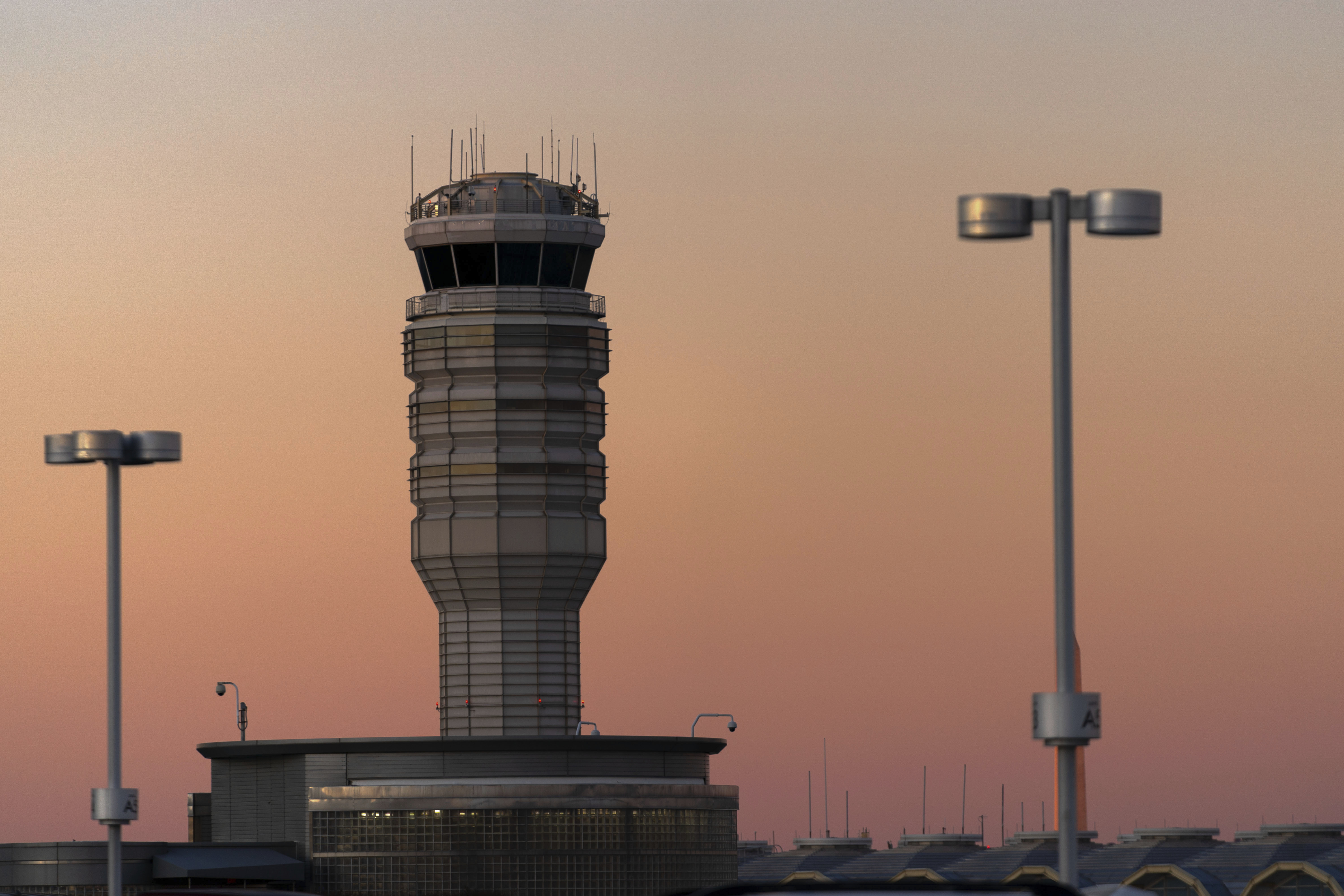 The air traffic control tower at Ronald Reagan Washington National Airport is seen at sunset, Feb. 1, in Arlington, Va. An American Airlines plane arriving there discontinued its landing to avoid getting too close to another aircraft departing from the same runway.