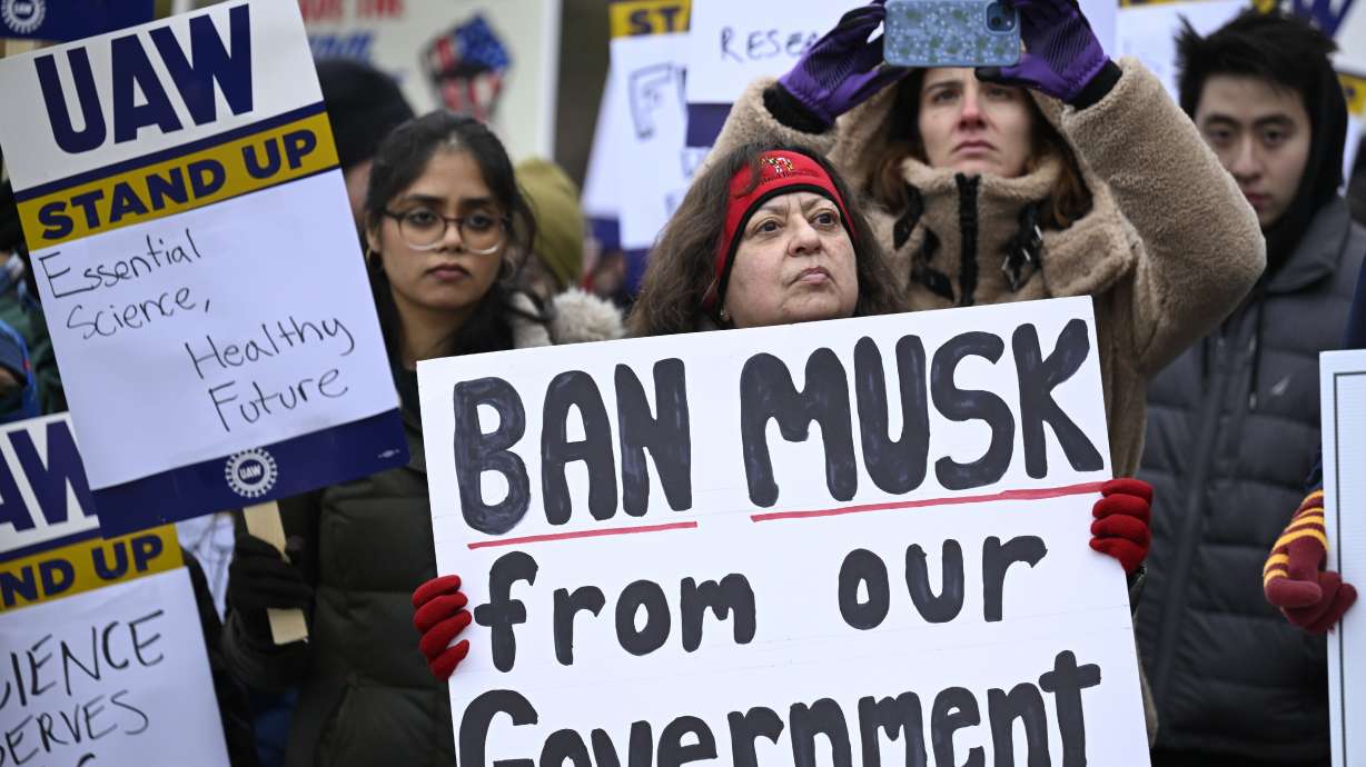 People rally at Health and Human Services headquarters to protest the polices of President Donald Trump and Elon Musk Wednesday in Washington. President Donald Trump's administration says federal agencies should begin planning to eliminate employee positions. The process is known as a reduction in force.