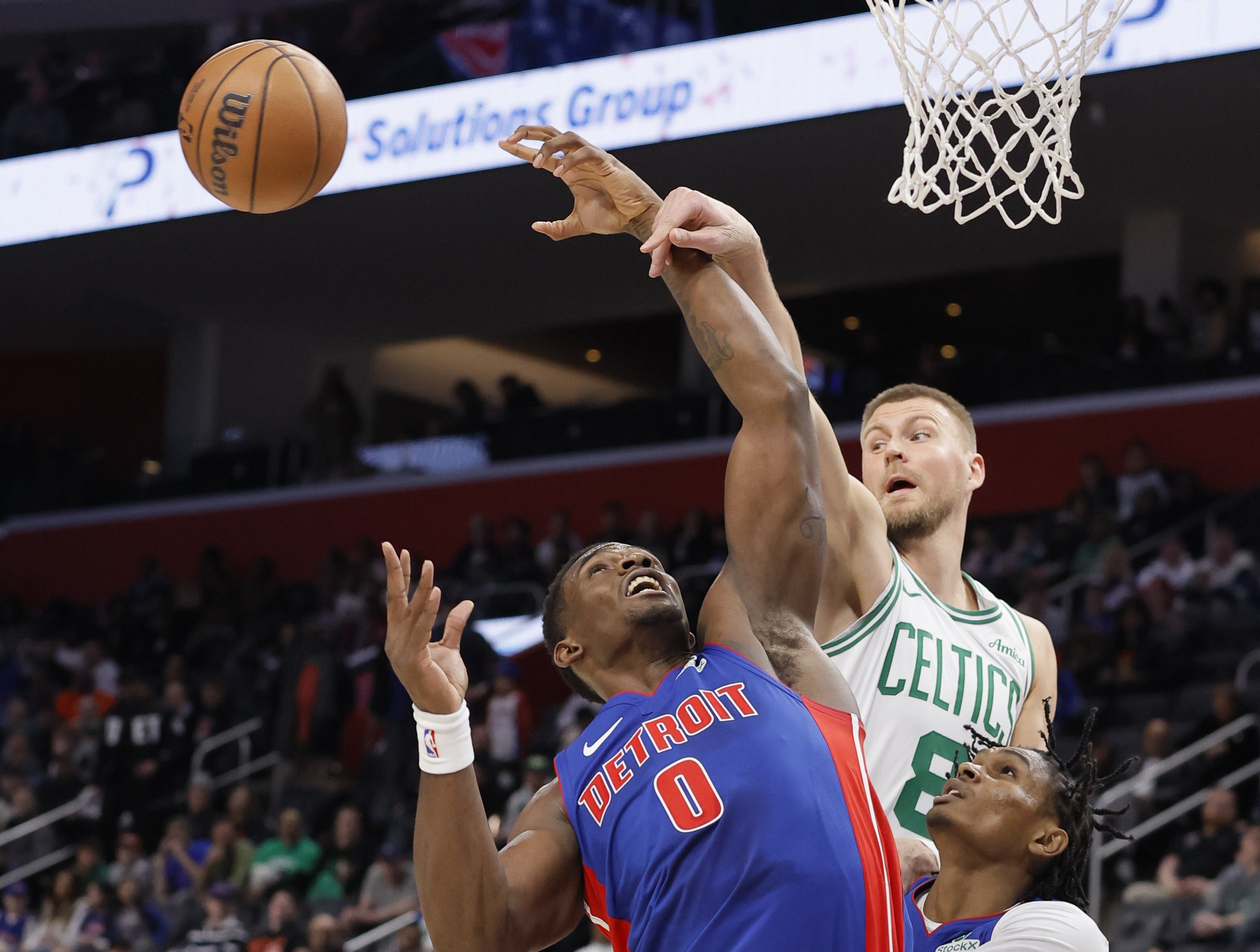 Boston Celtics center Kristaps Porzingis (8) passes the ball past Detroit Pistons center Jalen Duren (0) with forward Ausar Thompson looking on during the first half of an NBA basketball game Wednesday, Feb. 26, 2025, in Detroit. 
