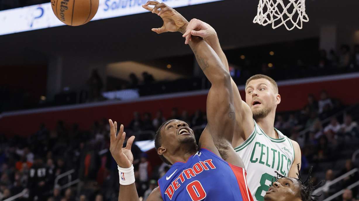 Boston Celtics center Kristaps Porzingis (8) passes the ball past Detroit Pistons center Jalen Duren (0) with forward Ausar Thompson looking on during the first half of an NBA basketball game Wednesday, Feb. 26, 2025, in Detroit.
