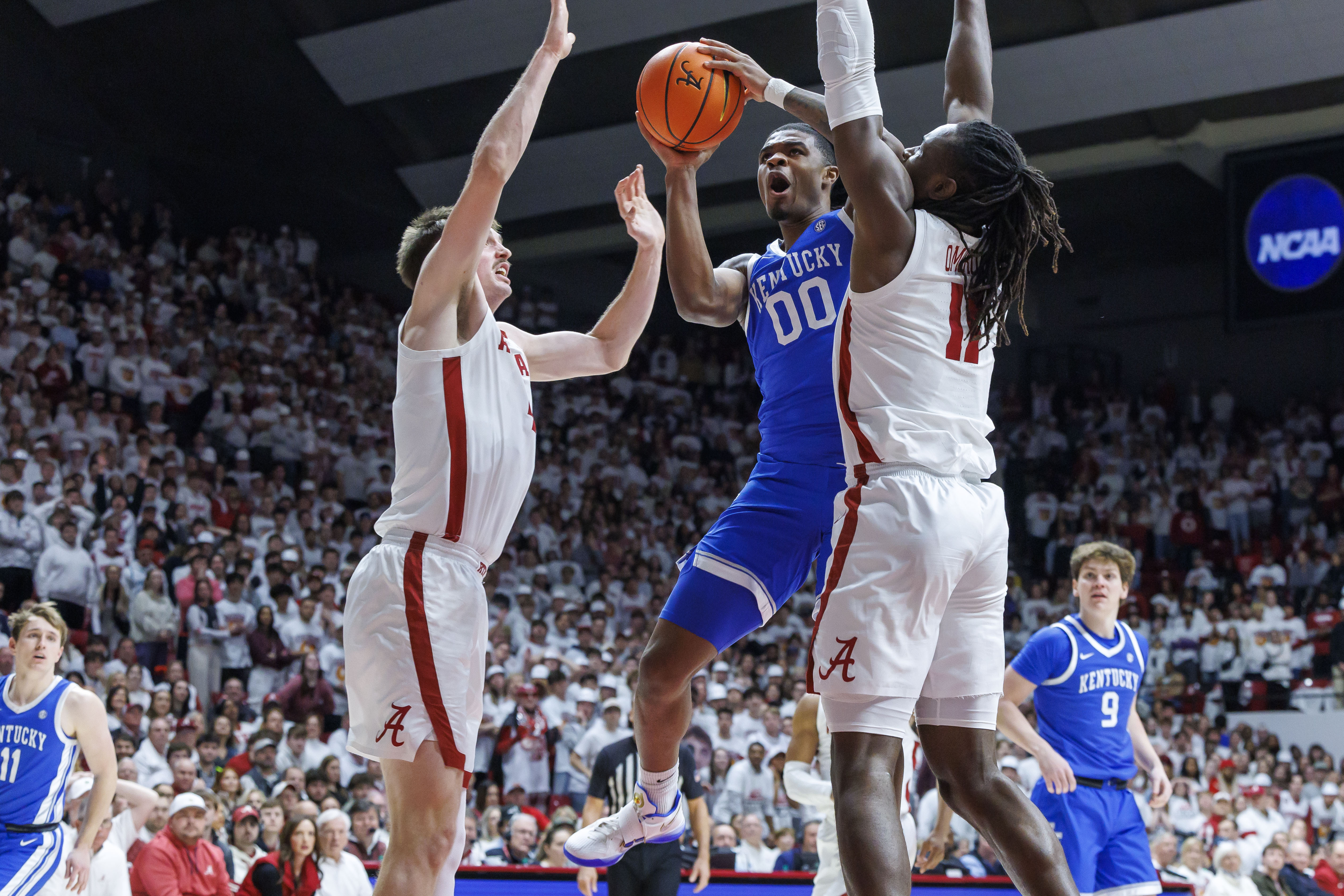 Kentucky guard Otega Oweh (00) works between Alabama forward Grant Nelson, center left, and center Clifford Omoruyi (11)) during the first half of an NCAA college basketball game, Saturday, Feb. 22, 2025, in Tuscaloosa, Ala. 