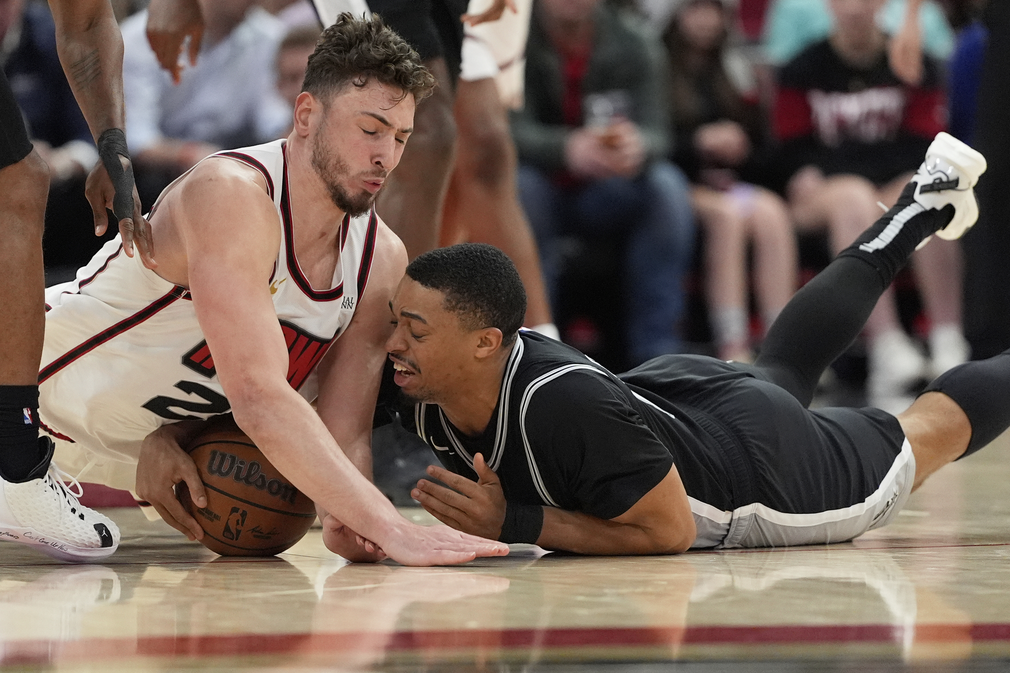 San Antonio Spurs' Keldon Johnson, right, battles Houston Rockets' Alperen Sengun for a loose ball during the second half of an NBA basketball game Wednesday, Feb. 26, 2025, in Houston.