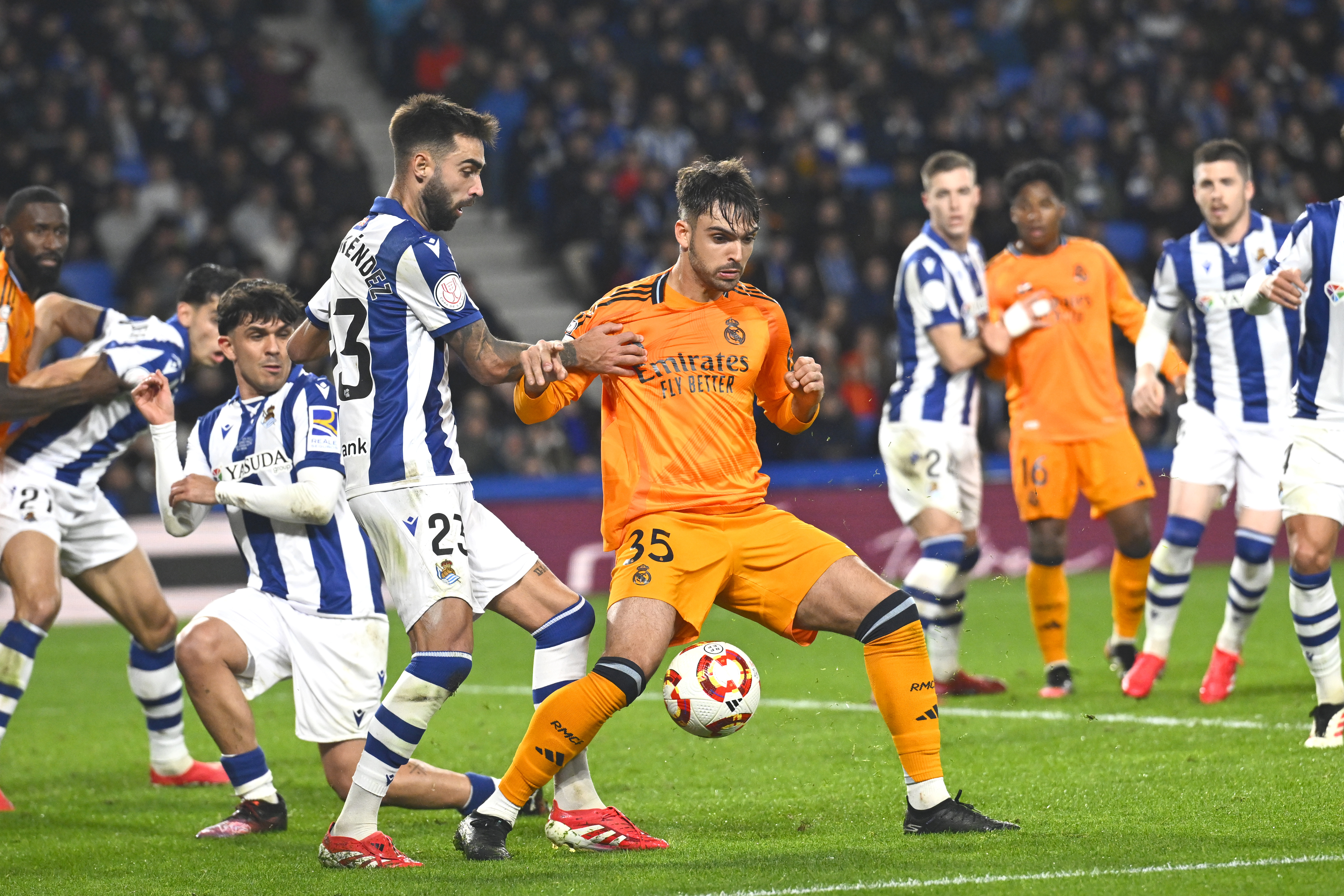 Real Sociedad's Brais Mendez, centre left, challenges for the ball with Real Madrid's Raul Asencio during the Spanish Copa del Rey soccer match between Real Sociedad and Real Madrid at the Reale Arena in San Sebastian, Spain, Wednesday, Feb. 26, 2025. 