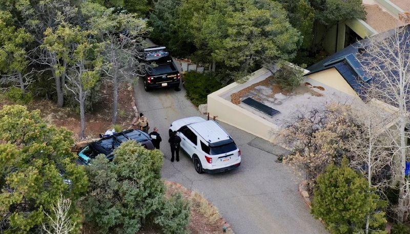 Law enforcement officials talk outside the home of actor Gene Hackman on Thursday, in Santa Fe, New Mexico. Hackman, his wife Betsy Arakawa and their wife were found dead in the home a day earlier.