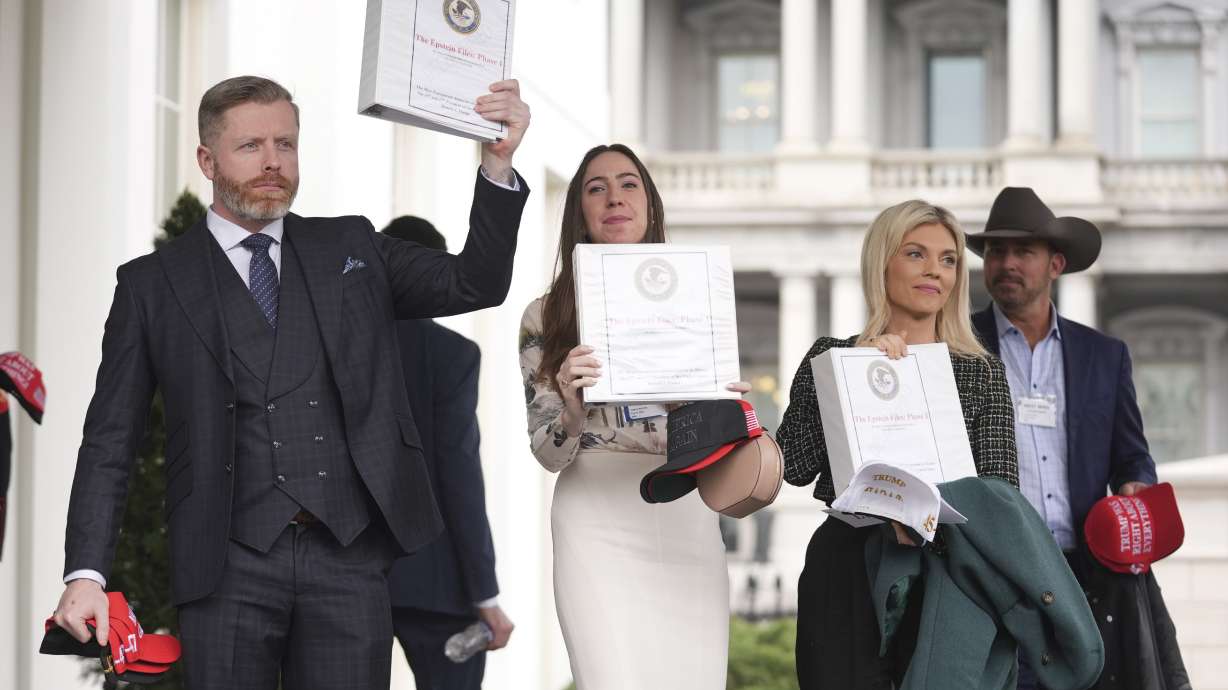 Rogan O'Handley, also known as DC Draino, from left, Chaya Raichik and Liz Wheeler hold up binders with a cover titled "The Epstein Files: Phase 1," with Jack Posobiec at the White House, Thursday, in Washington.