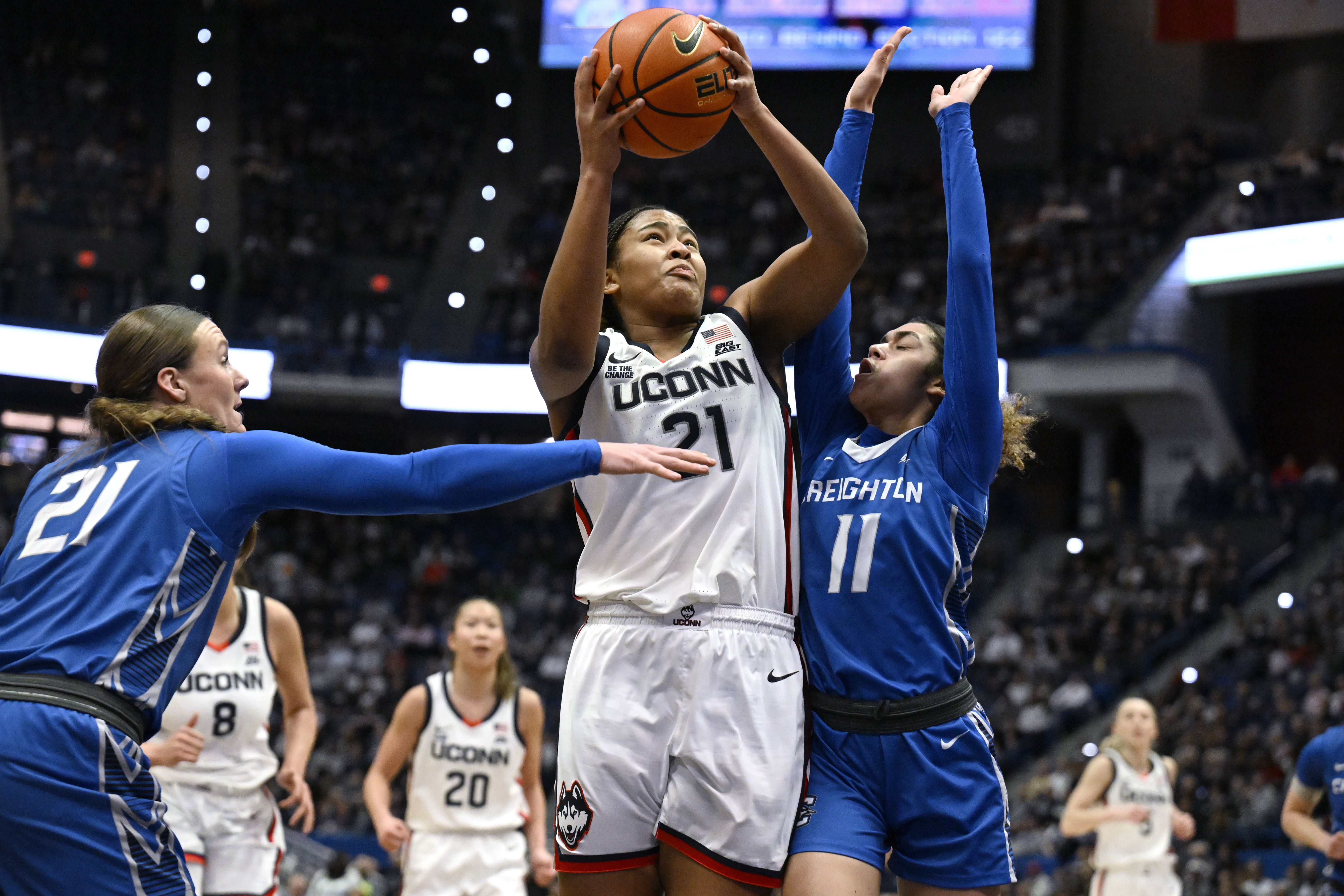 UConn forward Sarah Strong (21) shoots as Creighton guards Molly Mogensen (21) and Kiani Lockett (11) defend in the first half of an NCAA college basketball game, Thursday, Feb. 27, 2025, in Hartford, Conn. 