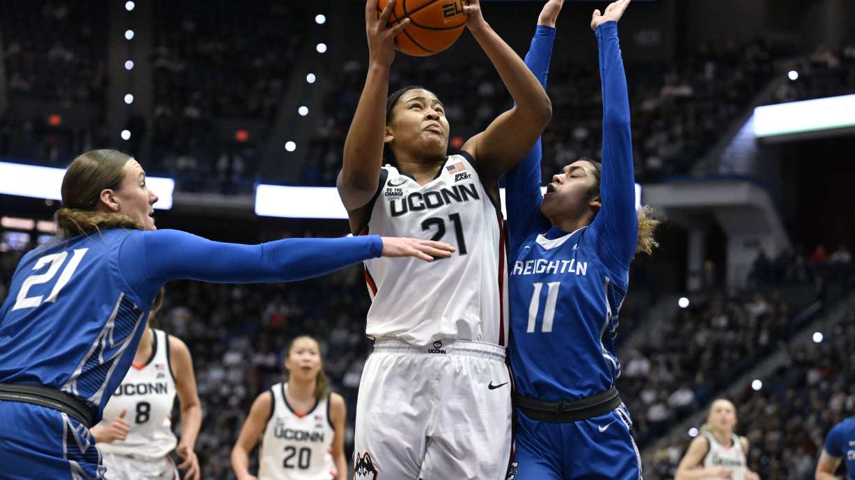 UConn forward Sarah Strong (21) shoots as Creighton guards Molly Mogensen (21) and Kiani Lockett (11) defend in the first half of an NCAA college basketball game, Thursday, Feb. 27, 2025, in Hartford, Conn.