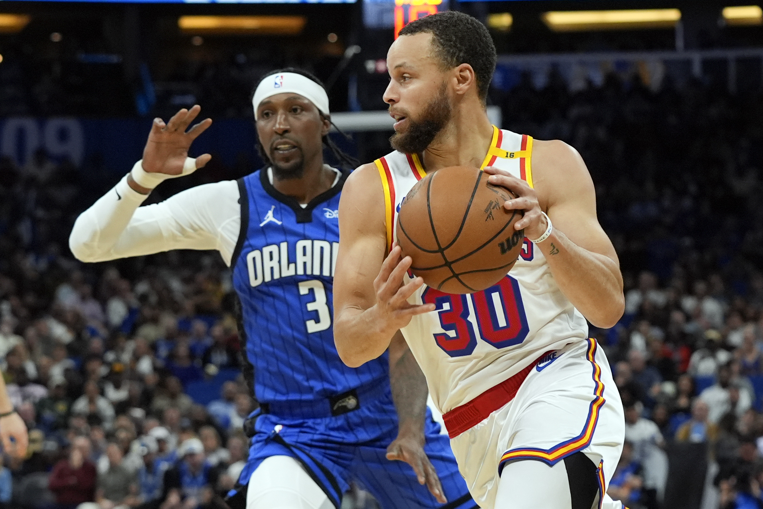 Golden State Warriors guard Stephen Curry (30) drives past Orlando Magic guard Kentavious Caldwell-Pope (3) during the second half of an NBA basketball game, Thursday, Feb. 27, 2025, in Orlando, Fla. 