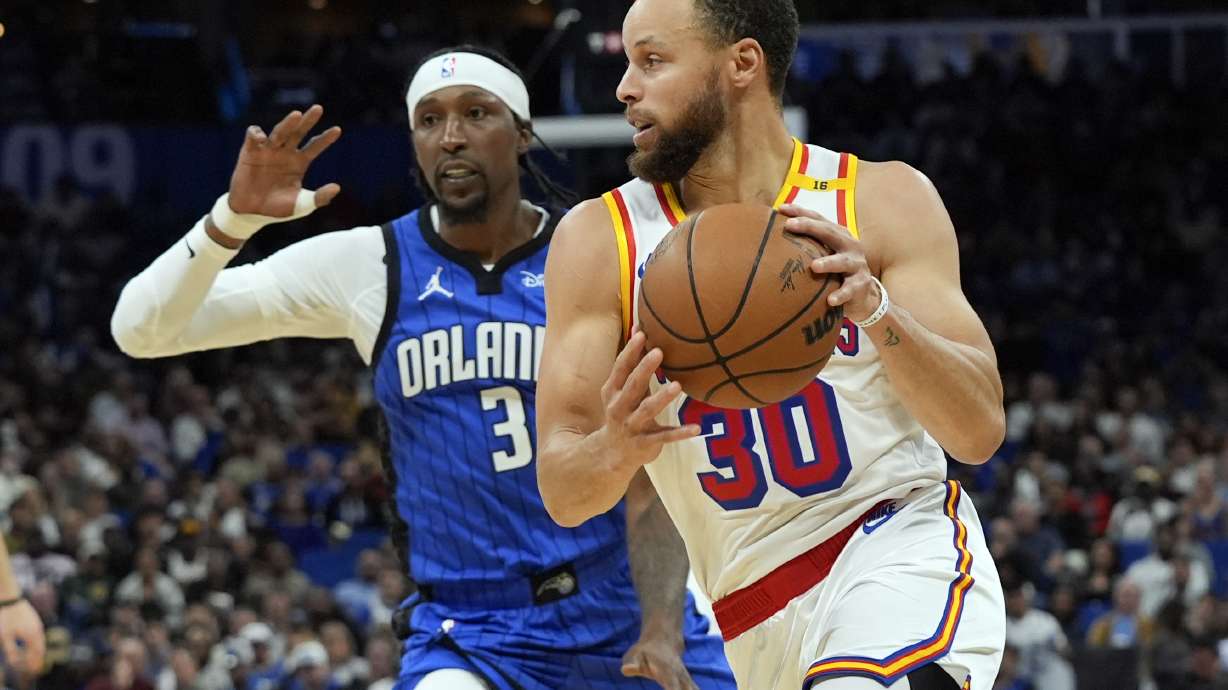 Golden State Warriors guard Stephen Curry (30) drives past Orlando Magic guard Kentavious Caldwell-Pope (3) during the second half of an NBA basketball game, Thursday, Feb. 27, 2025, in Orlando, Fla.