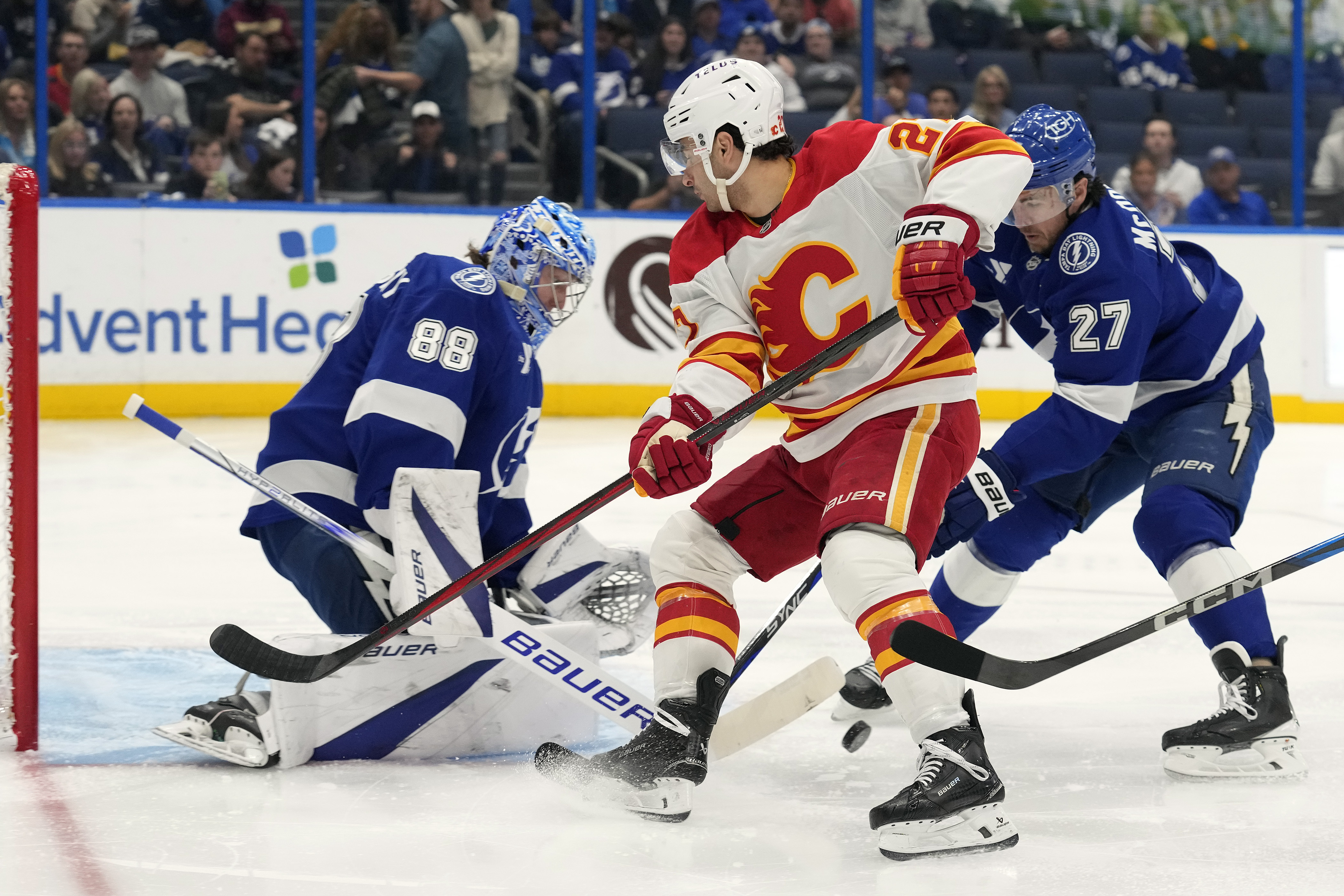 Tampa Bay Lightning goaltender Andrei Vasilevskiy (88) and defenseman Ryan McDonagh (27) team up to stop a shot by Calgary Flames right wing Matt Coronato (27, center) during the first period of an NHL hockey game Thursday, Feb. 27, 2025, in Tampa, Fla. 