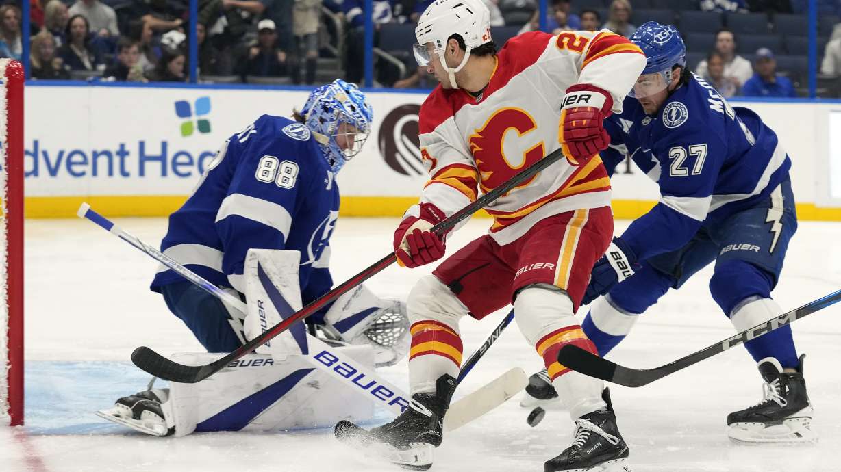 Tampa Bay Lightning goaltender Andrei Vasilevskiy (88) and defenseman Ryan McDonagh (27) team up to stop a shot by Calgary Flames right wing Matt Coronato (27, center) during the first period of an NHL hockey game Thursday, Feb. 27, 2025, in Tampa, Fla.