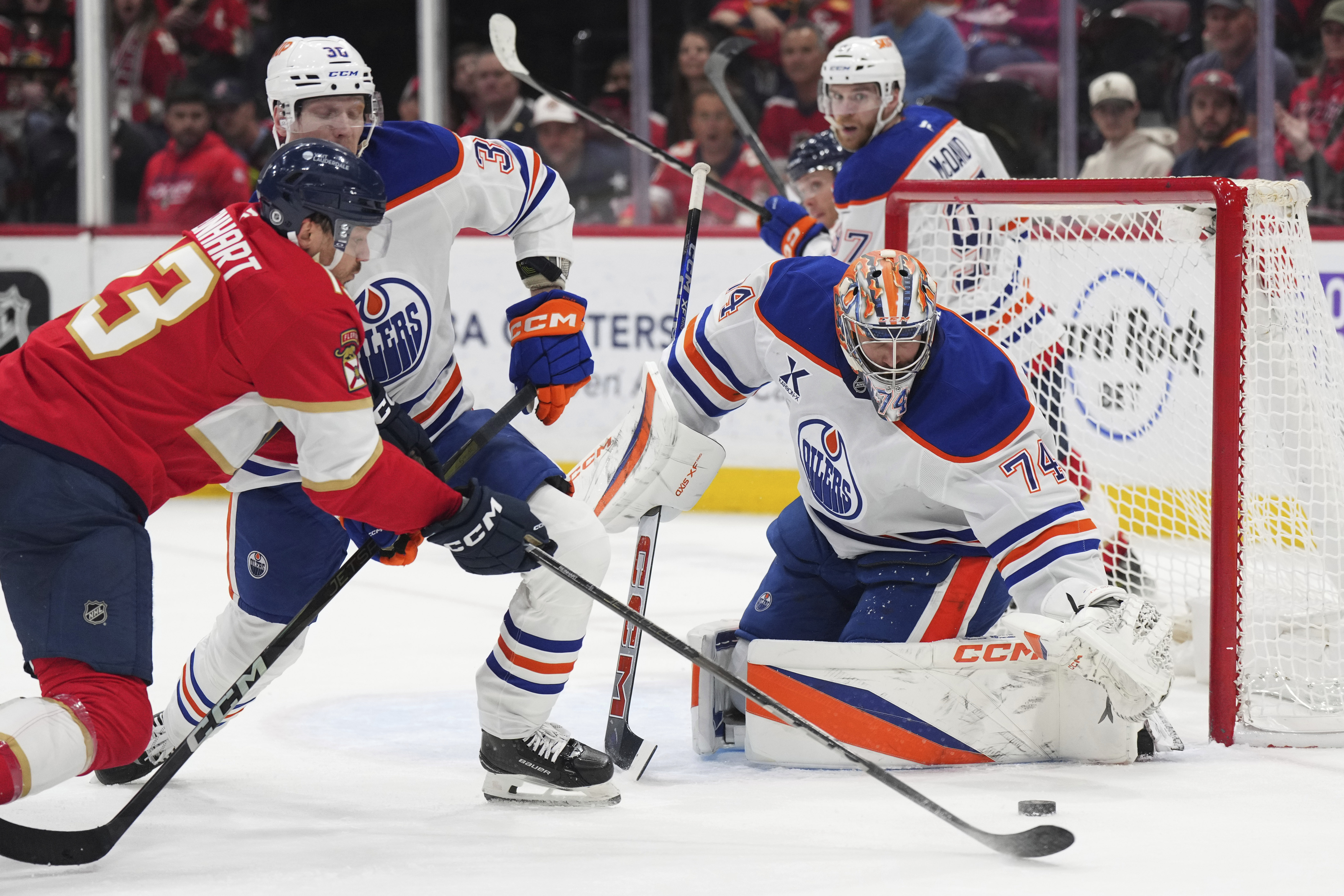 Florida Panthers center Carter Verhaeghe (23) reaches for the puck as Edmonton Oilers defenseman John Klingberg (36) closes in and goaltender Stuart Skinner (74) reaches for the puck during the first period of an NHL hockey game, Thursday, Feb. 27, 2025, in Sunrise, Fla. 