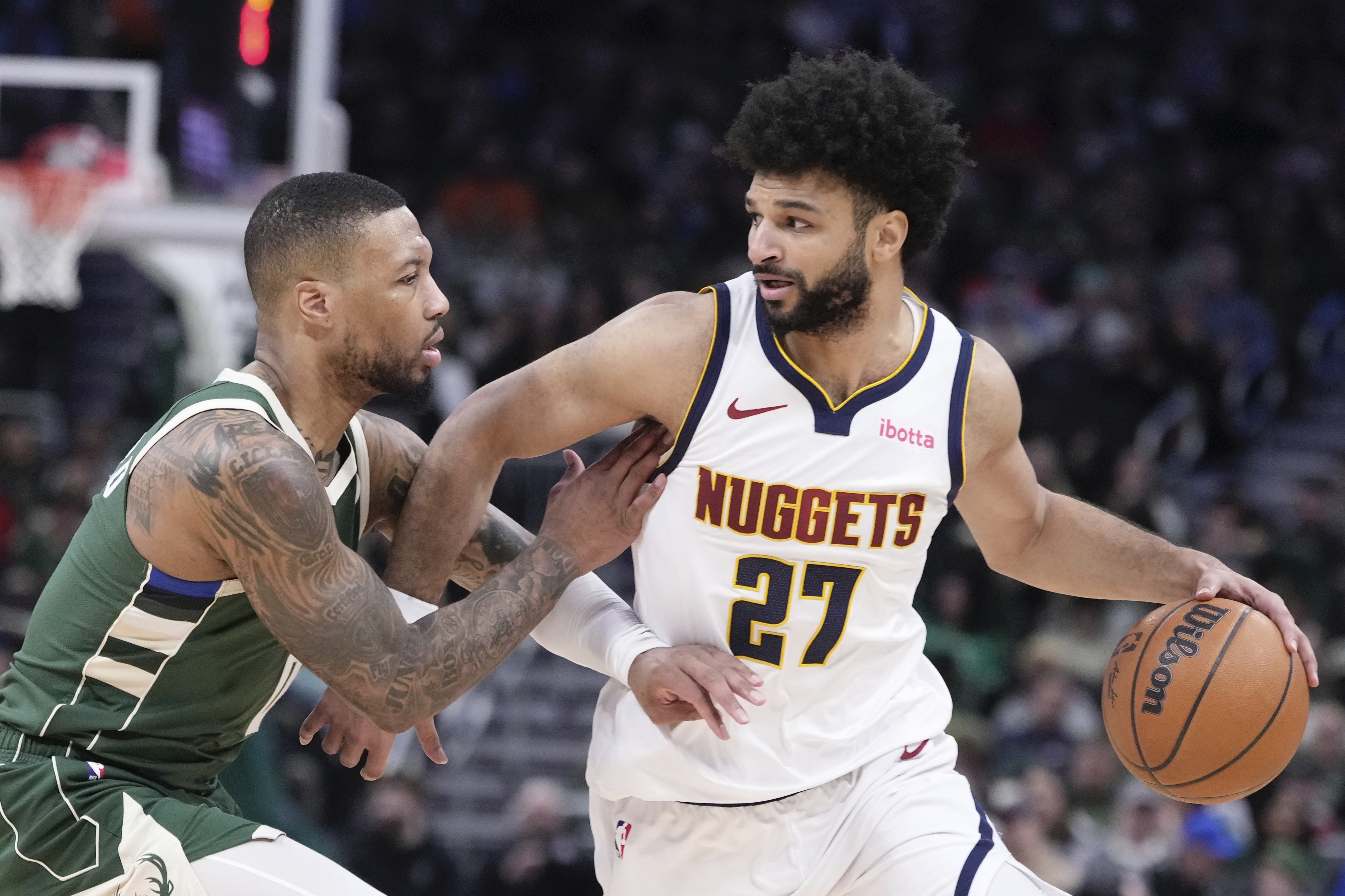 Denver Nuggets' Jamal Murray tries to get past Milwaukee Bucks' Damian Lillard during the first half of an NBA basketball game Thursday, Feb. 27, 2025, in Milwaukee.