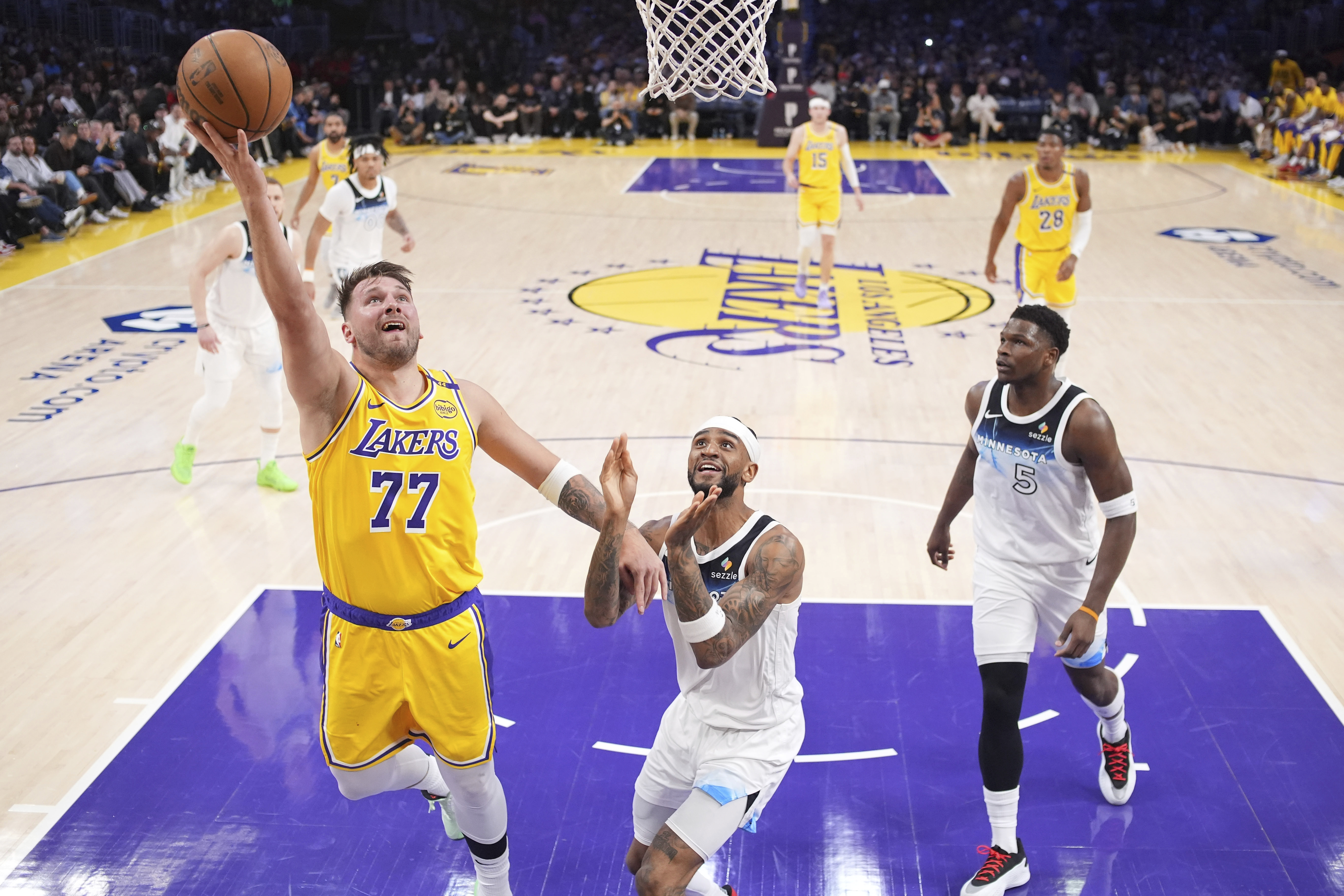 Los Angeles Lakers guard Luka Doncic, left, shoots as Minnesota Timberwolves guard Nickeil Alexander-Walker, center, and guard Anthony Edwards defends during the first half of an NBA basketball game, Thursday, Feb. 27, 2025, in Los Angeles. 